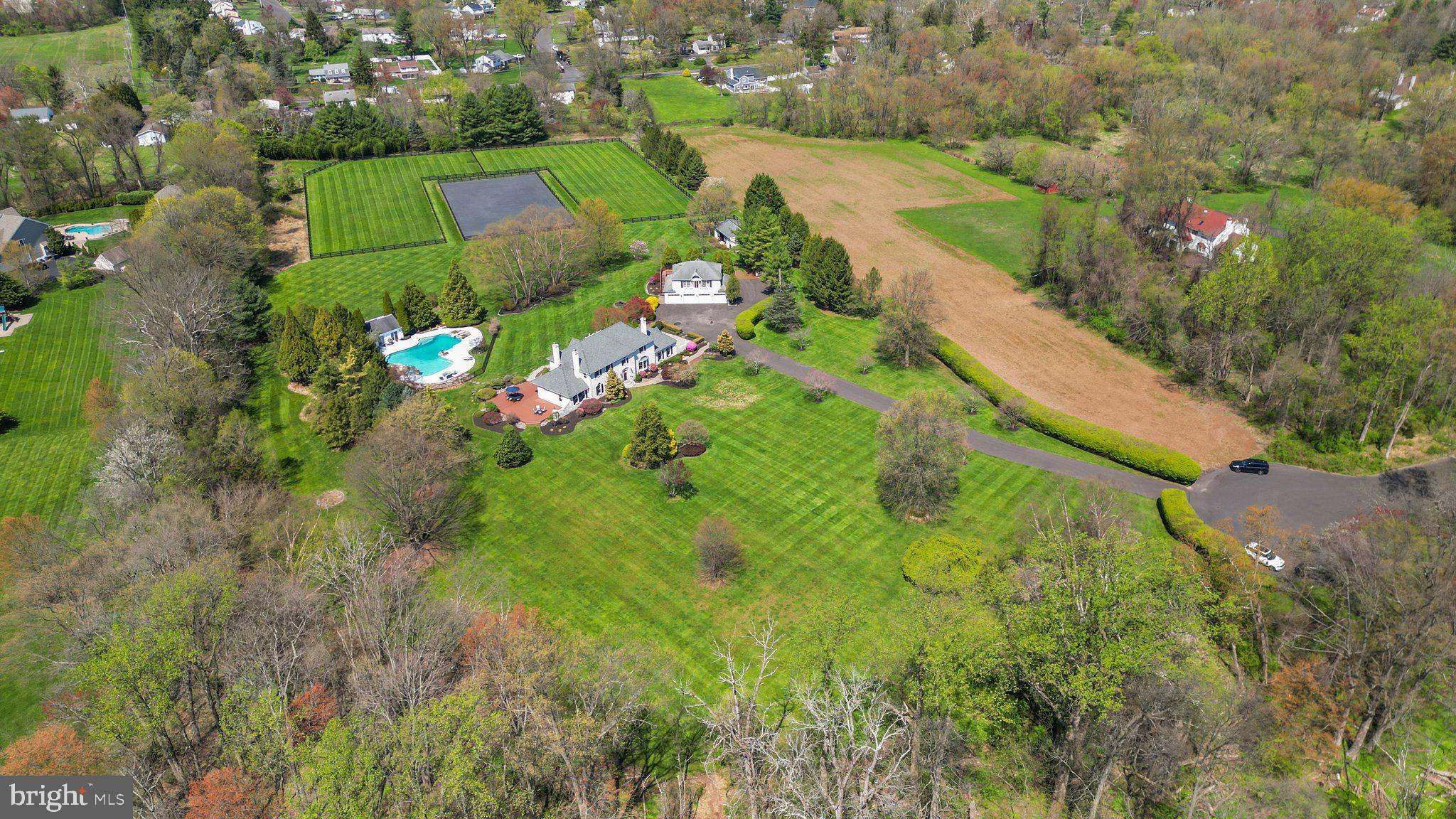 Nestled within the serene embrace of a private enclave known as Two Ponds lies an ‘equestrian’ estate in this magnificent sanctuary spanning over 10 lush acres. As you traverse these manicured grounds and beautiful paddocks, anticipation mounts for the grandeur that awaits within the 4500 square foot home that stands as the centerpiece of this picturesque domain! Stepping through the threshold, a dramatic yet understated foyer welcomes you, adorned with travertine flooring that highlights an elegant turned staircase. A sense of warmth envelops you as you enter the expansive living room, where one of the home’s five fireplaces flickers invitingly. Adjacent, a stylish dining room beckons; its’ own fireplace serving as a focal point amidst custom-built cabinetry, setting the stage for intimate gatherings and festive celebrations alike. You will love entertaining in your renovated chefs’ kitchen—the heart of this home—complete with gleaming granite counters, custom-designed tile backsplash, stainless steel appliances including an under-counter microwave/speed oven, and built-in JennAir® oversized refrigerator-freezer, as well as a huge walk-in pantry! The culinary space also boasts a lovely morning room to relax with coffee and the daily news. In addition, a generous kitchen dining area overlooks a comfortable family room with a built-in entertainment area and windows galore! With four bedrooms and 3.5 baths including a MAIN LEVEL bedroom-den opening to a private sunroom, this level finishes with a lovely work-from-home office where you can enjoy overlooking the luscious front yard during your working hours! Ascending to the upper level, the owner's suite awaits, a haven of tranquility featuring its own fireplace, a private deck overlooking this sprawling ‘equine’ estate, and a spa-like bath that promises respite from the cares of the world. With two additional bedrooms and a renovated hall bath, every corner of this abode is infused with comfort and luxury. A finished walk-out basement, and full bath, entices friends and family to watch play off sports and a partake in few rounds of billiards while enjoying libations at the built-in wet bar. The allure of this residence extends beyond the confines of the main residence, beckoning with amenities tailored for both relaxation and recreation and trotting the day away! A bonus custom-designed mudroom provides outdoor access to the paver patio! Across the drive is a phenomenal detached four-bay heated garage with half bath, offering plenty of space for vehicles and storage, with a second-level in-law QUARTERS providing additional accommodation for family or guests. For your EQUESTRIAN pursuits, a handsome barn stands at the ready, complete with three stalls, each with an individual run-out paddock, and a tack/feed room with beautifully stained wood and built-in storage! Nearby is a newly renovated riding ring with excellent drainage, alongside two large turn-out pastures, ensuring ample space for beloved equine companions to roam and graze. The pièce de résistance awaits after a day of riding or grooming, where an oasis of leisure unfolds before you! A 1500 square foot free form heated pool with jacuzzi, glistens in the sunlight, flanked by a pool house with powder room, offering respite from the summer heat. Here, outdoor gatherings come to life, as friends and family gather to bask in the splendor of this idyllic setting, enjoying meals prepared in the convenient service kitchen or simply lounging on the pool deck soaking in the sun. Located near shopping, dining, and main thoroughfares, this estate offers the perfect blend of seclusion and accessibility, ensuring that every desire is within reach. For those seeking the epitome of ‘equestrian’ living, look no further than this stunning estate—a haven where luxury, comfort, and the timeless beauty of nature converge, creating a legacy for a new family of equestrians!