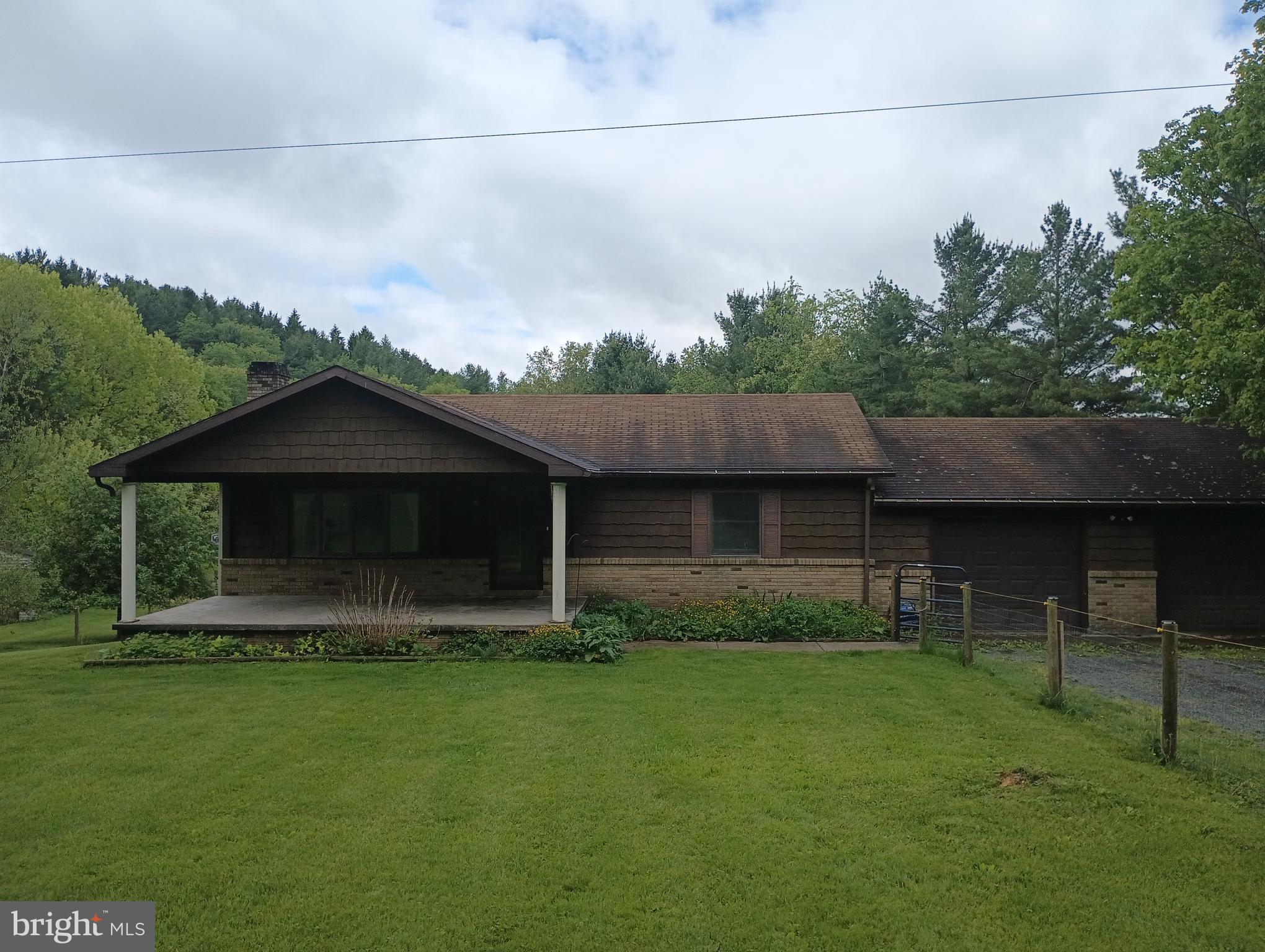 They call it Pleasant Valley for a reason! The property features a 2+ acre wooded area, a serene stream, several berry plants, 2 sheds, chicken coop, and a rear deck. Front porch and a fenced-in front yard. Inside, there is a large, bright living room, an updated kitchen with plenty of cabinet space, appliances, and sliding glass doors leading to the deck. The bathrooms have been updated. Full basement offers a laundry area, a full bathroom, and a convenient walkout to the backyard. Two car garage. Whole house generator included. Sold “AS IS”.