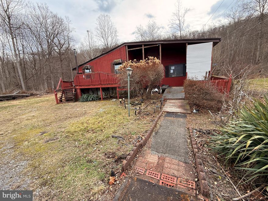 Investor opportunity in LaVale! Situated on approximately 0.83 acres, this property offers a private wooded setting with convenient access to LaVale and Cumberland amenities. The property includes a primary residence of approximately 1,818 square feet along with a separate cabin/guest structure, both conveying strictly as-is.

The main residence features a unique layout and a loft-style upper level overlooking the main living space. Large windows provide natural light and views of the surrounding landscape. Multiple decks and outdoor spaces offer potential for future outdoor living areas once restored.

The structures are in significant disrepair and will require extensive renovation or possible redevelopment. Visible concerns include deteriorated decking, unsafe exterior stairs, aging roof components, and interior flooring and structural elements requiring evaluation. The additional guest cabin on the property is also in poor condition and may require removal or complete reconstruction.

Due to condition, cash or renovation financing will be required. This property presents an opportunity for experienced investors, builders, or buyers seeking a project with land value and redevelopment potential.

Conveniently located in Allegany County with public sewer service and easy access to local amenities.

Sold strictly AS-IS.