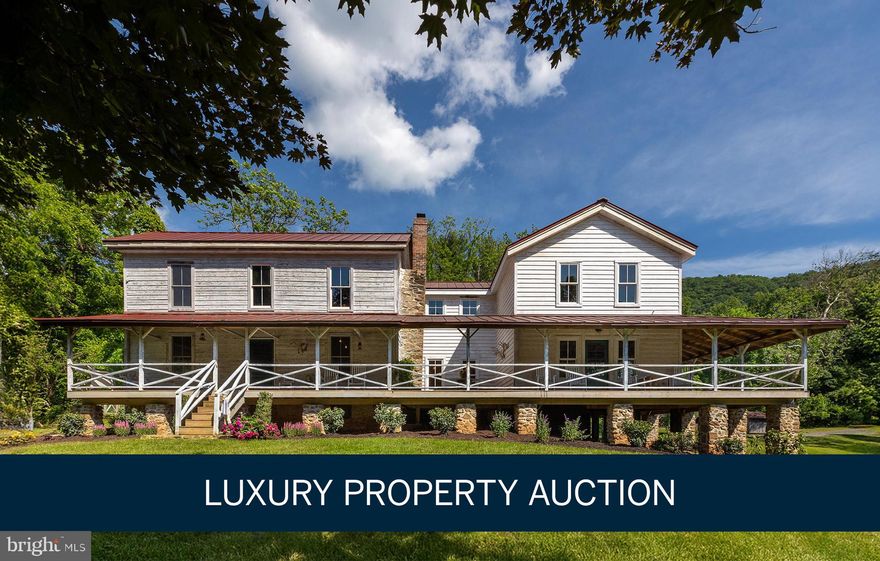LUXURY PROPERTY AUCTION: 21–27 JANUARY.
OPEN HOUSE:  Saturday January 17, 1:00 - 3:00 pm
Accepting Starting Bids Through 20 January.
Starting Bids Expected Between $1M–$2M.
Earn an incentive by 20 January.

A rare private nature preserve awaits on 106 pristine Virginia acres directly adjoining Shenandoah National Park and Skyline Drive. This extraordinary retreat—completely reimagined by an award-winning designer—offers world-class panoramic views of the Shenandoah River, Valley, and Blue Ridge Mountains from an iconic circa-1875 farmhouse with authentic period details. Four separate primitive retreat cabins accessible by ATV provide accommodation for 20 guests, creating unparalleled versatility as a family compound, hunting lodge, or recreation estate. The property unfolds across verdant forests, streams, three ponds, massive rock outcroppings, and extensive trail systems. Original homestead structures include a barn, smokehouse, spring house, vintage train caboose, and root cellar. Minutes from Washington DC, this personal preserve delivers the experience of owning a piece of Shenandoah National Park.