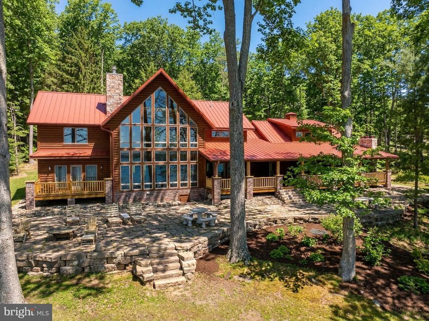 Stunning lakefront log home offering the perfect blend of rustic elegance and modern comfort. Boasting 181 feet of pristine waterfront, this 4-bedroom retreat features four en suite bedrooms. Three of the suites have their own fireplace that creates a warm, cozy ambiance throughout. The abundance of windows allows you to enjoy the beauty of the outside during any season from every level of this wonderful home. The open floorplan and upgraded kitchen feature an island and Corian countertops, providing ideal space to enjoy with family and friends. Enjoy breathtaking lake views from the expansive, covered outdoor deck, which also offers an outdoor fireplace—ideal for relaxing or entertaining year-round. The firepit and type A dock are just steps away and provide even more enjoyment. The central location on a dead-end road is unmatched, as are the gorgeous sunrises! This is a rare opportunity to own a private waterfront escape with exceptional charm and character.