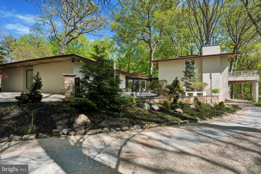 Welcome to this spectacular modern masterpiece, tucked away on the most desirable private cul-de-sac in East Falls. This architecturally striking custom home offers approximately 5,500 square feet of beautifully designed living space, set on a serene, meticulously landscaped 1.4-acre lot overlooking the lush Wissahickon Park. Surrounded by mature trees and nature, this home is a true sanctuary—just minutes from the city, yet worlds away in feel.

The home is defined by dramatic design elements, including soaring 10’ ceilings, walls of glass, floor-to-ceiling windows and doors, and multiple skylights that flood every room with natural light. Every 8’ window and glass door offers an uninterrupted connection to the outdoors, framing peaceful views in every direction.

The impressive entry is approached via a cedar walking bridge and trellis, leading to a double glass door foyer with elegant porcelain tile flooring, coat closet, and a powder room.

The open-plan living and entertaining spaces include a stunning Garden Room with glass wall enclosures, floor-to-ceiling windows, three skylights, and a gas fireplace—ideal for both relaxing and hosting. A sliding glass door opens directly to an expansive outdoor deck oasis, offering seamless indoor-outdoor flow and the perfect setting for dining al fresco, entertaining, or simply enjoying the tranquil natural surroundings.

On the upper level, a refined family room with Brazilian Cherry floors, a custom Roche Bobois built-in wall unit, and another gas fireplace with marble surround offers an additional retreat with access to a private deck. This level also includes a private bedroom, perfect for guests, a home office, or multigenerational living.

Another very large living room on the lower level features a gas fireplace, wall of windows and sliding glass doors that open to yet another spacious deck with panoramic views of the park.

Three of the home’s four bedrooms are located on the main level, offering ultimate convenience and accessibility. The private main suite features floor-to-ceiling glass doors opening to a deck, dual walk-in closets with custom shelving, and a spa-inspired bath with Corian countertops, Grohe fixtures, travertine tile floors, an oversized shower with frosted glass doors, a whirlpool tub beneath a skylight, and ample natural light.

The two additional bedroom suites on this level each include walk-in closets, full baths with travertine or tile flooring, oversized showers, and their own access to outdoor deck areas—ideal for guests or family members seeking privacy and comfort.

A striking, light-filled kitchen and dining space that blends form and function with exceptional style. Designed for both everyday living and elegant entertaining, this area features sleek Thermofoil cabinetry, granite countertops, a glass backsplash, and top-tier stainless steel appliances, including Miele double ovens, microwave, warming drawer, dishwasher, and wine cooler; a 6-burner Fisher Paykel cooktop; GE Monogram refrigerator; and GE stainless steel trash compactor. A custom 10-foot banquette with upper cabinets adds warmth and dimension. The generous dining area is bathed in natural light and easily accommodates a table for 10 or more—perfect for family gatherings or large dinner parties.

Additional Amenities:
Large 2-car garage with capacity for 8+ cars parking in the driveway
Attached room currently used as a gym
Small basement, perfect for storage
Built-in surround sound system indoors and out
Custom lighting throughout by Bulb, and custom shades on all windows

If you are searching for a modern urban retreat that offers peace, privacy, and proximity to the city, this one-of-a-kind East Falls estate delivers. Quiet, refined, and immersed in nature—yet just 12 minutes from Center City—this is your opportunity to own a true contemporary oasis.