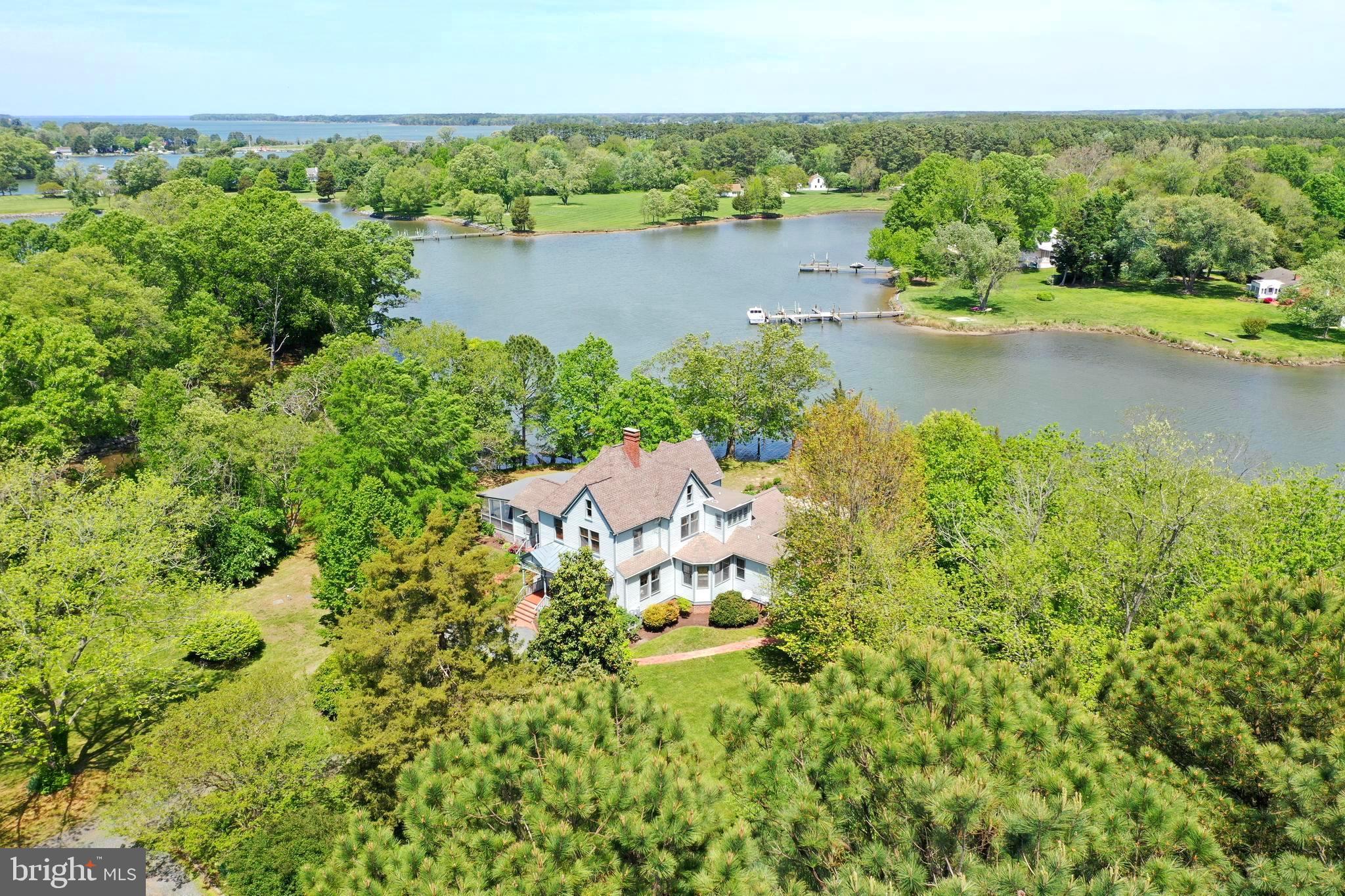 This house is a showstopper! A work of art that feels part castle, part cathedral! Pictures don't do it justice! It's a unique, historic, waterfront estate that combines privacy & nature & excellent location on Oak Creek between St. Michaels & Easton. The treelined drive welcomes you to this one of a kind home built in 1890 and situated on 11.59 acres. Featuring stained glass transoms, the original staircase, heart pine wood floors, 10 foot ceilings, oversize windows, custom triangular door frames, 3 beautiful & unique fireplaces, main level primary suite with living room & private entrance & sliding doors to the huge wrap around 38x40 screened in porch with beamed wood ceiling. The custom designed kitchen with pine craftsman cabinetry & breathtaking dining room with 16 ft cathedral ceiling look out over the garden lined pool, waterfront & artfully refurbished dock with 3.5 ft water depth. The living room has the original French doors, carved fireplace mantel & stained glass transom. Unique, historic, triangular side-by-side fireplaces in the family room . Charming sunroom with lots of light off the family room. Upstairs is a second primary bedroom that includes attached luxury, spa bath in wood & marble & 6 closets! The second floor also has a waterview guest bedroom, original curved hallway, full bath & fabulous bright office studio with amazing views over the pool & water. The third floor suite includes a bedroom, full bath, studio living room, cedar walkin closet & impressive gothic window & skylight. Basement/crawlspace is fully encapsulated. Detached garage for gardening, tools & workshop. PLUS the property includes a beautiful private art/music/camping cabin in the woods! Designed by the owners for their passion for art & music. The interior of the cabin is unfinished with electric only but full of potential! Check with Talbot County for more information on hunting, farming, additional accessory dwelling units & short term rentals. Excellent location near T's General Restaurant, Oak Creek Sales, Post Office & the historic Oaks Inn!