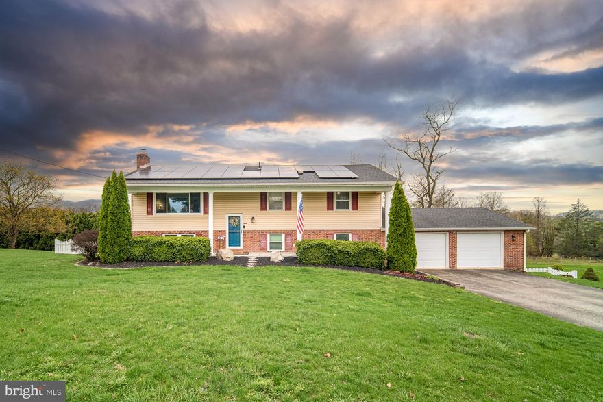 Enjoy the space provided in this country but close low maintenance home.  Panoramic views off the expansive deck.  Updated kitchen with  bar counter and  granite countertops.  Spread out in a lower level exposed to the rear for fabulous living space as family room and plenty of additional room for exercise gym or hobby.  Solar panels provide a net zero $ supply of electricity (see additional info in docs and seller disclosure. Fantastic fenced yard and much convenience: additional storage building, a full bath on each level,  2 car garage and double drive  for additional parking.