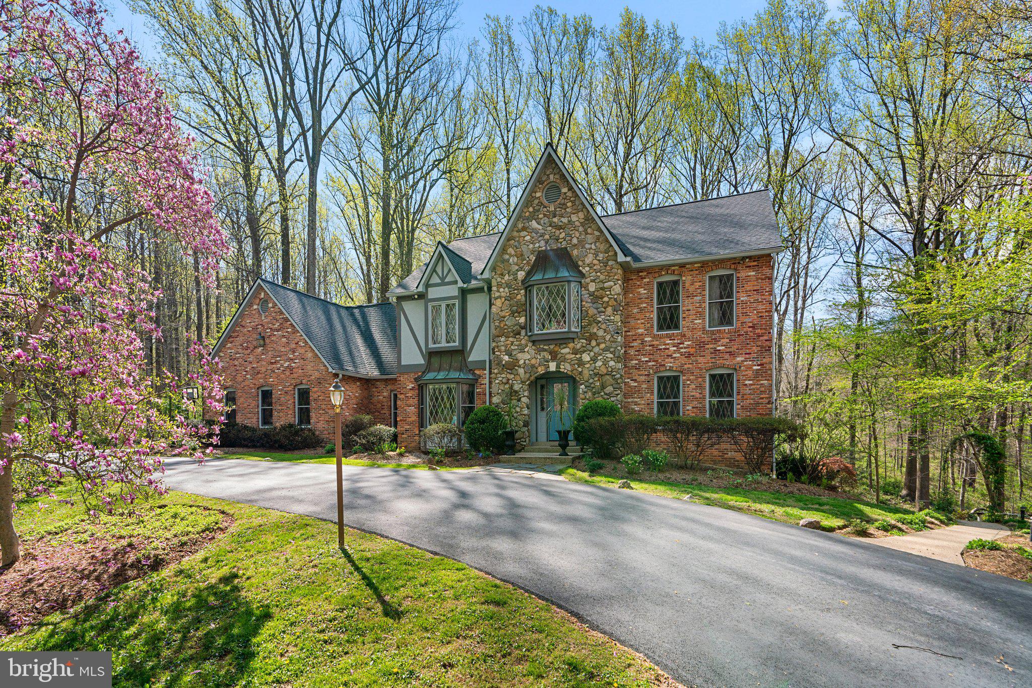 Step out of a storybook and into your dream home. Tucked away on a private, picturesque 5-acre tree-lined lot, this showstopper will leave you speechless with every turn. Take a minute to appreciate the serenity this home's location offers as you stand on the front porch underneath the arched-stone entryway. Inside, you will notice a unique sense of style, true to this home's architecture. Wooden trim, hardwood floors, creamy paint, and classic details throughout! The formal living room offers endless possibilities. Don't miss the office/den, which makes the perfect spot to work from home; tree-lined views from every angle! The family room is the perfect space to entertain. Floor to ceiling stone fireplace, arched window and door detail, stunning woodworking, and sight-lines straight into the fully renovated and gorgeous kitchen. No expense was spared during this kitchen renovation. High-end cabinetry, massive island, stainless appliances, and a workflow that chefs dream of! Room for a kitchen table, or take advantage of the spacious dining room with spectacular bay window. Upstairs you will find 4 massive bedrooms. The primary suite is the definition of luxury with it's own fireplace, dressing area, walk-in closet, and expansive en-suite bathroom complete with a soaking tub, dual vanity, and walk-in shower. The basement has been completely renovated and is fully fitted as a separate apartment or just an amazing entertaining space. Two additional bedrooms, a full bath, second kitchen, and walk-out doors to the stunning backyard. Options for use include an au-pair suite, in-law suite, accessory rental apartment, the opportunities are truly endless. The backyard oasis is the cherry-on-top, with a fully covered gazeebo, large deck, and additional patio below, you will feel like you are miles outside of town while being minutes from everything Olney/Brookeville/Ashton has to offer. You won't want to miss this one, so call us for your private showing TODAY!