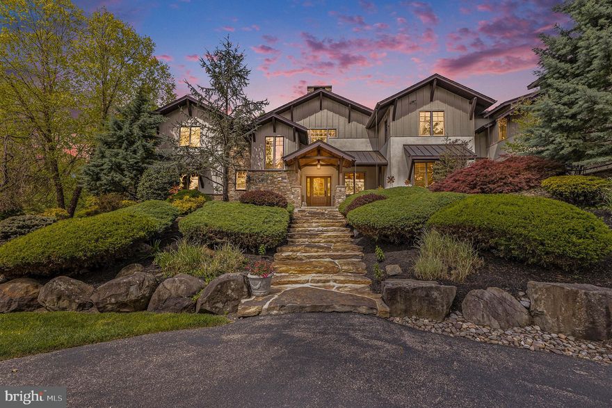 Presenting 825 Lewis Lane, an exceptional property meticulously designed by Architect Rene Hoffman and crafted by Gwynedd Valley Builders. This unparalleled estate, evoking the essence of a prestigious Aspen retreat, stands as a beacon of luxury unlike anything you’ve seen in the Philadelphia Area. Set on over 3 ½ acres adjacent to conservation land, this 9,780 square foot residence offers an upscale yet relaxed lifestyle offering a rare blend of seclusion and accessibility. As you approach the gated entrance, nestled far from the road, the allure of this estate becomes evident. The circular drive leads to the Fieldstone-covered entryway where a Mahogany front door opens to reveal quarter-sawn oak flooring that extends throughout the main floor. The two-story great room boasting floor-to-ceiling Fieldstone double fireplace and expansive windows and doors, sets the grandeur within. Adjacent, the gourmet kitchen with radiant heat flooring features a large center island and top-of-the-line appliances, including a Wolf Professional Gas Range, Sub Zero refrigerator and warming drawer complemented by a spacious breakfast room with access to the outdoor terrace. Entertaining is a delight in the formal dining room and adjacent butler’s pantry, complete with a copper hammered sink, dishwasher, wine refrigerator, ice maker, and ample storage. Indulge in the ultimate convenience with a walk-in pantry, kitchen office with custom workstation, well-appointed laundry room and a central vacuum system. A full bathroom and a mudroom provide practicality, ensuring every need is effortlessly met within arm’s reach. Discover the oversized three-car side entry garage, offering ample space for your vehicles and storage needs. Equipped with GarageTek shelving modular cabinetry, this garage combines functionality with design. The main floor master suite offers a sanctuary of serenity, boasting panoramic views of the lush grounds, dual walk-in closets, dressing area and a spa-like bathroom with soaking tub and steam shower. Upstairs one ensuite bedroom has two large walk in closets, a cedar closet and a full marble bath with glass shower. Head down the hall overlooking the great room to the second ensuite bedroom with a large closet, full stone bath with glass shower. Two additional bedrooms (one with a walk-in closet) have a Jack and Jill full bath with two marble vanities. The second-floor laundry and large bonus room complete the second floor. The lower level offers endless entertainment possibilities, with a sophisticated marble bar, complete with integrated refrigerator drawers, a billiard area, glass enclosed exercise studio and a state-of-the-art home theatre with leather stadium seating. Find your inner sommelier in the glass temperature-controlled wine tasting room and wine cellar. The full marble bath and large utility room with mechanicals, storage, and a great woodworking space with access to the secondary stairwell add practicality and functionality. Outside the allure of resort-style living continues on the expansive flagstone terrace with a professionally equipped outdoor kitchen, stone fireplace and covered dining area. The heated pool with spa, newly surfaced tennis/pickleball court/basketball half court and a private walking/jogging trail afford an active lifestyle right at home. The immaculate landscaping, complemented by a custom-designed irrigation and lawn sprinkler system with a dedicated water well also for the pool creates a verdant oasis for relaxation and recreation. Extensive hardscaping and landscape lighting as well as a house generator ensure both beauty and safety. Conveniently located near shops, restaurants, parks and major roads, this property offers the pinnacle of luxury living. With nearby amenities such as golf courses, country clubs, private schools, and Wings Field for private jet travel, 825 Lewis Lane truly epitomizes exceptional living.