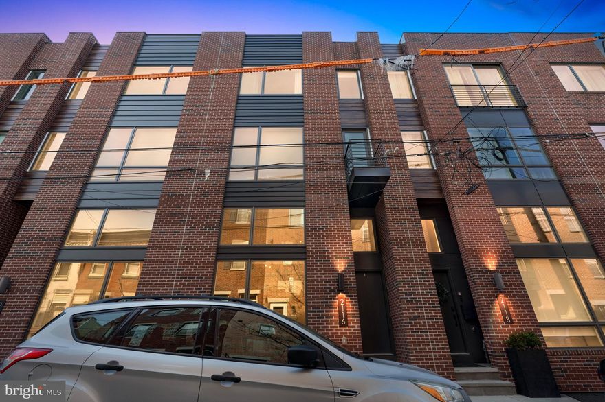 Don’t miss this luxury townhome with 2-car garage parking. This extra-wide modern townhome is located in an ideal location close to Center City, public transportation and highways, universities, and hospitals. The 20-foot wide home offers nearly 3,300 square feet of living space, custom-designed finishes, and unmatched center city views from the roof deck. The expansive living room features 15-foot high ceilings and an open floor plan with hardwood floors and a massive wall of windows and custom blinds throughout. A center staircase leads to the dining area, overlooking the living room, and the gourmet kitchen. The convenient powder room, with stunning wallpaper and gold fixtures, completes this level. The kitchen is a chef’s dream, with a center island, quartz countertops, subway tile backsplash, and stainless steel Bosch appliances, including a drawer microwave, cooktop, double oven, and range hood. Exit through the back of the kitchen to the rear deck, which extends 8 feet off the rear wall—perfect for entertaining, outdoor grilling, and dining. Upstairs, you’ll find two spacious bedrooms with large closets and huge windows, as well as a full bathroom with a dual-sink vanity. This floor also includes a laundry room with an LG washer and dryer, and cabinets for additional storage. The top floor features the primary suite, with gorgeous center city views through the north-facing windows. The massive walk-in closet has been meticulously designed to maximize space. The en-suite bath offers a freestanding soaking tub, an oversized shower with frameless glass, a private lavatory, a double vanity, heated floors, Grohe fixtures, and a seaglass tile accent wall. Leading up to the roof deck, you’ll find a wet bar and sink, perfect for entertaining guests, as well as another powder room with a wallpaper accent and teal wainscoting. The roof deck is complete with green roof finishes and offers spectacular panoramic views of the Philadelphia skyline. Additional living space can be found in the finished basement, which receives great natural light through the front window. This space is ideal for an office, workout room, or playroom. Conveniently located near restaurants like Dock St Brewing and Sidecar Bar & Grill, as well as essential stores such as Target, Sprouts Market, Whole Foods, PetSmart, and the PA Fine Wine & Spirits.