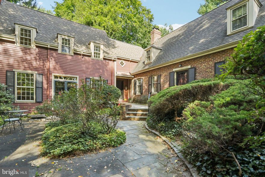 On the market for the first time in nearly 30 years, this classic Chestnut Hill residence is a rare opportunity in an idyllic setting just steps from Fairmount Park. Tucked away in the woods and nestled behind a beautifully landscaped garden courtyard, the home blends timeless architecture with versatile living spaces in a location that offers both privacy and convenience. The main level opens with a gracious entry hall and wide-plank hardwood floors that extend throughout much of the home. At its heart is an expansive, high-ceiling grand room—the first half of a thoughtful two-story addition—designed for gathering, with a wood-burning fireplace, tall windows, and French doors leading to the courtyard. A stately dining room, breakfast nook, and compact yet efficient kitchen provide wonderful natural light and serene views from nearly every angle. With six separate doors opening to the outdoors, this home seamlessly connects the interior to its natural surroundings, creating a rare sense of peace and flow. Also on the first floor is a flexible suite with a full bathroom, ideal as a den, fourth bedroom, or guest quarters, along with a convenient laundry closet. Upstairs, the primary suite, forming the second half of the addition, features refinished floors, generous closet space, and a full bathroom. The other two spacious bedrooms flank a bathroom and a convenient second staircase. Outdoors, the private courtyard retreat is framed by lush plantings, with space for both quiet mornings and evening barbecues and outdoor dining. Just beyond the garden, Fairmount Park offers endless opportunities for recreation, while the shops and restaurants and convenience of Germantown Avenue are moments away. Lovingly maintained and thoughtfully expanded, this home offers a unique combination of character, livability, and location. Properties of this quality and setting rarely come to market—an exceptional opportunity not to be missed.