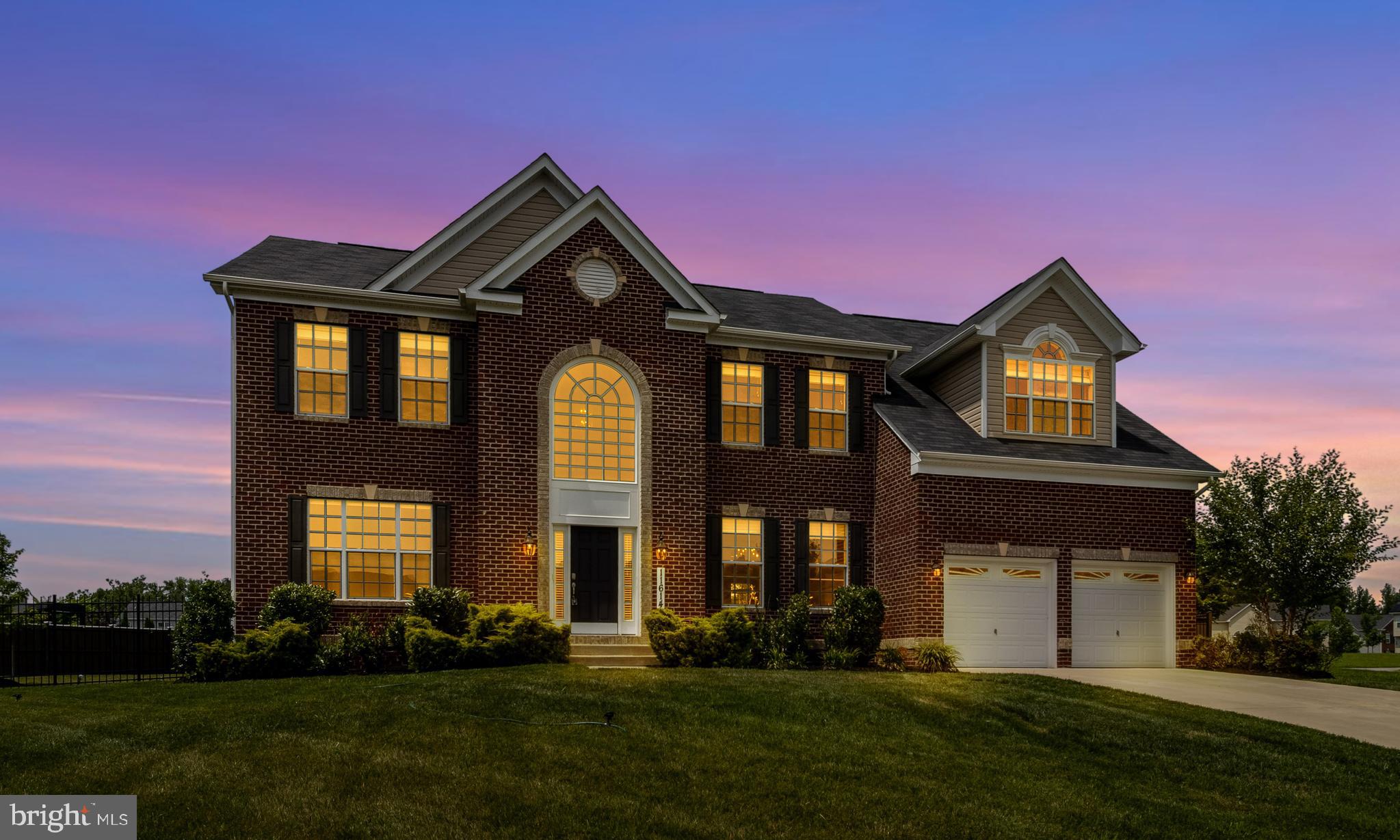 Welcome to this elegant brick-front Kingsport model by Caruso Homes, beautifully sited on a cul-de-sac in sought-after Fort Washington Acres. Adjacent to the community sports field and just steps from the tot lot, tennis courts, and walking trails, this exceptional estate offers both privacy and convenience in a tranquil, upscale setting. The grand 2-story foyer, with its gleaming hardwood floors and sweeping dual-entry staircase, sets the tone for a home defined by space, light, and timeless sophistication. To the left, a formal living room bathed in natural light; to the right, a refined dining room with tray ceiling, chandelier, crown, and chair molding—perfect for elegant entertaining. At the heart of the home is the great room, featuring soaring ceilings, a dramatic wall of windows with remote-controlled blinds, a ceiling fan, and a gas-log fireplace for warmth and ambiance. The open-concept design flows effortlessly into the gourmet kitchen and morning room—an entertainer’s dream. Enjoy granite countertops, 42" cabinetry, a gas cooktop, double wall ovens, stainless steel appliances, an oversized island, recessed and pendant lighting, plus a built-in desk and pantry. The morning room provides access to a airconditioned sunroom addition, leading to a spacious, fenced rear yard with 6 foot tall privacy fencing on the rear and sides and attractive see through fencing on the front with locking gates. A private library, powder room, and mudroom with laundry and garage access complete the main level. Upstairs, a walkway that overlooks the great room and foyer, leads to the luxurious primary suite featuring vaulted ceilings, a separate sitting room with built-ins and dry bar, and four closets—including two walk-ins. The spa-inspired Caribbean bath offers dual vanities, two private water closets, a soaking tub, and a dual-entry shower with dual heads—designed for comfort and retreat. Three additional generous bedrooms and a full hall bath complete the upper level. The fully finished lower level is an entertainer’s haven—boasting a large family room with built-ins, rec room space, and a bar area (plumbed for wet bar conversion). The dedicated theater room comes equipped with a projector, screen, speakers, and a three-tiered platform, with soft theater lighting, for seating providing the ultimate cinematic experience. A full bath, additional carpeted storage room, and direct access to the backyard through a sliding glass door complete this level. Additional features include: dual-zone high-efficiency HVAC, a whole-house water conditioning system, luxury finishes throughout, and a 2-car garage with automatic openers. All of this is just minutes from National Harbor, MGM, and major commuter routes to Washington, DC. This is the one you’ve been waiting for—luxury, location, and lifestyle in perfect harmony.