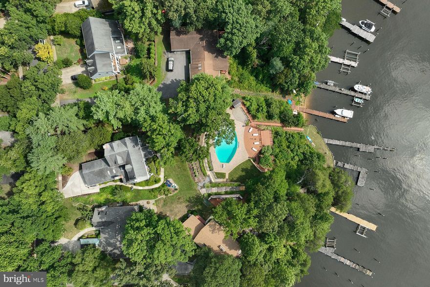 INCREDIBLE OPPORTUNITY to enjoy one of the finest waterfront properties in Annapolis: 365 and 367 Broadview Lane in desirable Broadview Estates are being sold together. 367 Broadview Lane is a 1930 waterfront home that has had multiple updates by the current owners, including several bathrooms, the kitchen, tankless water heater, and the installation of a sauna. This lot includes a private pier with 4+ ft water depth. 365 Broadview Lane is a separate parcel that features one of the most spectacular pools in Anne Arundel County, with gorgeous paver patio and recently replaced decking and retaining walls. This lot also has a private pier on Broad Creek and an unfinished “bonus room” under the main pool deck. Together, these properties create an unforgettable waterfront experience.
The home has a gracious floor plan, with formal dining and living rooms – flanking the original foyer – facing the water. The living room offers a gas fireplace and pretty glass doors transition to the family room. A waterside porch offers a serene dining experience with concord grape vines as the “ceiling.” The renovated kitchen is steps from a huge family room, with vaulted ceiling, gas fireplace, and skylights.  There is a mudroom with tons of storage, and a wet bar that facilitates the morning coffee. Beautiful hardwood floors and 5-panel doors in most rooms. The home offers three bedrooms on the second floor, including a primary suite that has a large sitting room with gas fireplace, jetted tub and Broad Creek Views. The other two bedrooms on this level share a renovated bathroom and have water views. There is a 4th bedroom, with bathroom and sitting room, on the top level. There is also a full bath on the main level, and a shower and sauna on the lower level. Broadview Estates is in an excellent location off Riva Road, and there is public water, sewer, and natural gas in the community. PLEASE DO NOT WALK ON PROPERTY WITHOUT AN APPOINTMENT.