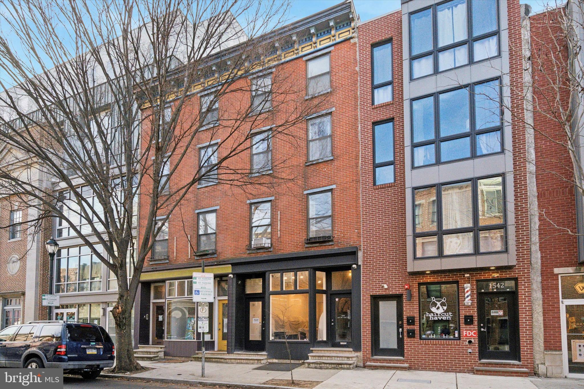 Rarely offered, this 4-story brick-front building includes more than 2,900 sq. ft. of above-ground living and commercial/retail space, situated on one of the most desirable blocks of South Street. 1540 South St. offers a store on the main/street level, a 1-bedroom apartment on the second floor, and a bi-level 2-bedroom apartment on the third and fourth floors. The second-floor apartment has its own private balcony at the rear, and the bi-level apartment features a private deck. The store and both apartments are equipped with central air conditioning. The entire property is occupied by long-term tenants.
Note that the store has a private entrance, separate from the apartments. Even better, the store boasts a large bay window, ideal for display on the high-traffic 15th block of South Street. The store also offers high ceilings, a private office area, a powder room, and a small backyard. The property has a full basement, accessible from both the store and the street through Bilco doors.
The second-floor 1-bedroom apartment is bright, boasts hardwood floors, and includes a private balcony at the rear. The top bi-level 2-bedroom apartment is modern, bright, and boasts a skylight, hardwood floors, and a large private deck. Note that the roof, where some mechanicals are located, can be accessed via a pull-down stair.
This unique property was custom rehabbed in the 1980s by an architect who ensured that every part of the property receives ample daylight. This feature is even felt in the main staircase, which accesses the apartments and charms with an exposed brick wall. Even better, the property offers a generous amount of storage space in each unit.
Own a one-of-a-kind 4-story building right next to the historic Royal Theatre, surrounded by numerous restaurants, shops, and everything that Rittenhouse Square, Graduate Hospital, and Broad Street have to offer. Learn more about 1540 South St. today.