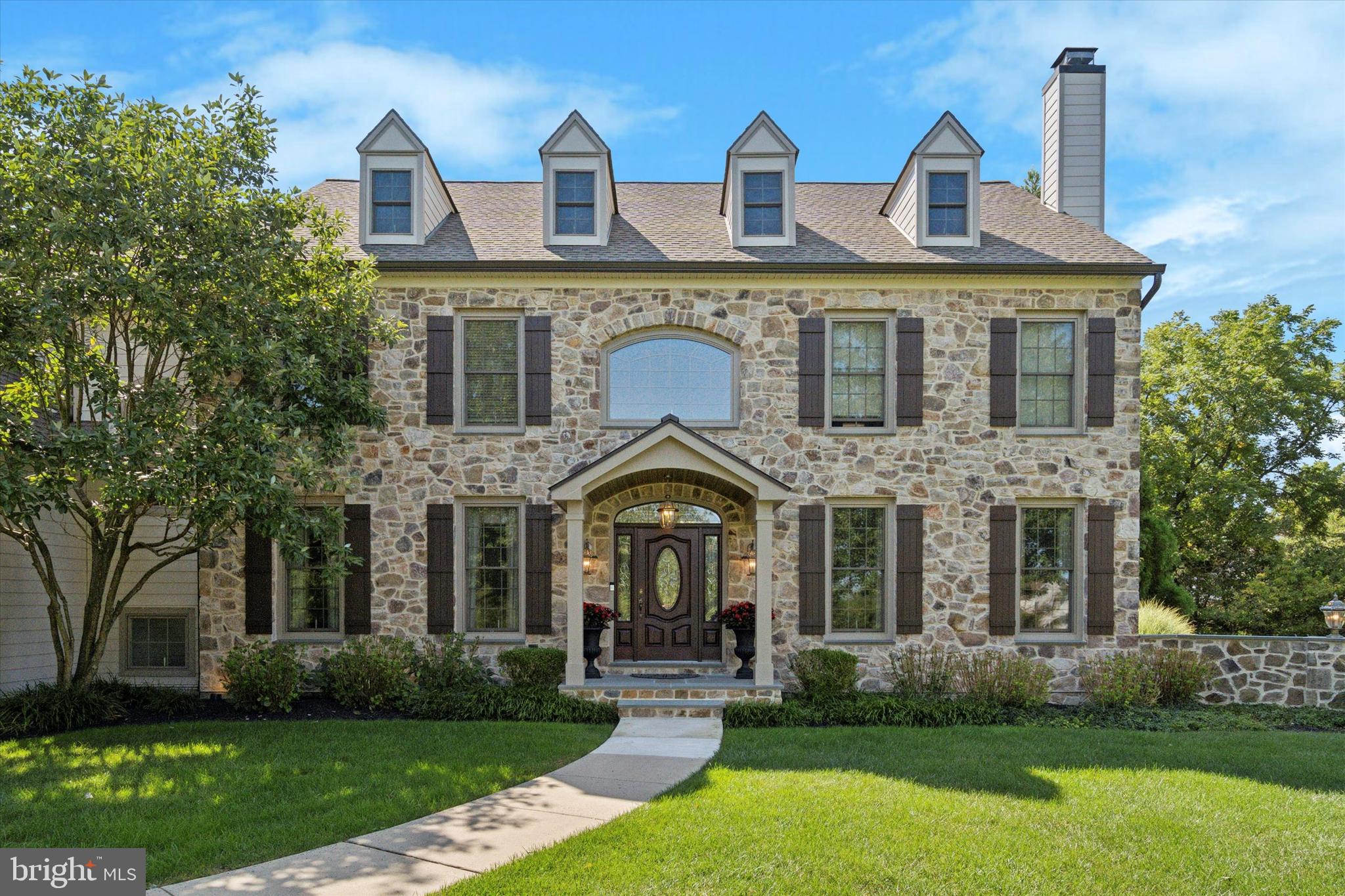 Exquisite Custom Estate with Timeless Elegance and Thoughtful Luxury
Welcome to a home where sophistication meets comfort. This custom-built 4-bedroom, 3 full bath, 2 powder room estate offers just over 6,000 square feet of beautifully curated living space, perfectly set on nearly 1.5 acres in the bucolic Worcester Township.
From the moment you enter the grand marble foyer—with its sweeping staircase and charming window seat—you’ll feel the craftsmanship, attention to detail, and pride of ownership that define this exceptional property. Just off of the foyer is the formal dining room with trayed ceiling and wainscoting, elegant living room with gas fireplace, private office, and the first of two powder rooms set the stage for both grand entertaining and intimate gatherings.
At the heart of the home is an expansive, two-story family room with a striking floor-to-ceiling stone gas fireplace and integrated home theater system—perfect for movie nights or hosting guests in style. The adjacent gourmet kitchen is a chef’s dream, outfitted with a Wolf gas range, Viking paneled refrigerator, wine fridge, ice maker, oversized island, and custom cherry cabinetry with crown molding. A sun-drenched breakfast room opens seamlessly to the rear patio, where a private hot tub surrounded by lush landscaping invites you to relax and unwind.
Upstairs, the luxurious primary suite offers a serene escape with a tray ceiling, dual walk-in closets, a private sitting area, and a spa-inspired ensuite bath featuring dual vanities, vaulted ceiling, jetted soaking tub, and glass shower. Additional bedrooms are generously sized and thoughtfully appointed, including a hall bathroom with access to Bedroom #3 and a private guest suite with walk-in closet and dedicated dressing area. The second-floor attic offers an additional 200 sq. ft. of storage, easily accessible and ready to suit your needs.
The fully finished lower level is an entertainer’s paradise, complete with a custom-built bar, beverage refrigerator, 400+ bottle wine cellar, fitness room, home theater with projector, and a walk-up private entrance. A rough-in for an additional powder room and abundant storage space add flexibility to this already impressive space.
Recent exterior renovations include new stonework, Hardie Plank siding, roof, gutters, and raised-seam metal roof accents—ensuring beauty and durability for years to come. Additional thoughtful upgrades include custom moldings, upgraded brass hardware, an indoor/outdoor sound system, dual-zone heating and cooling, two staircases from basement to first floor, and dual 200 AMP electrical panels.
This is a rare opportunity to own a truly exceptional home where every detail has been considered and no expense spared. The only thing left to do is move in and enjoy.