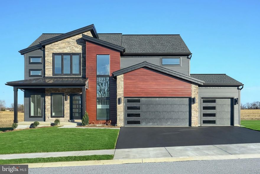 Striking contemporary home features a welcoming front porch, stylish exterior, a 3-car garage, and basement. The garage opens to a mudroom complete with a large pantry, powder room, and a built-in bench. The first floor boasts durable vinyl plank flooring and 9’ ceilings. To the front of the home is a flex room that can be used as a study, living room, or other versatile space. The kitchen is well-appointed with quartz countertops, a tile backsplash, and enhanced cabinetry and appliances. Adjacent to the kitchen is a sunny dining area with access to the rear composite deck with railings to grade and a comfortable family room warmed by a cozy fireplace with floor to ceiling stone. The 2nd floor owner’s suite features an expansive closet and a private bathroom with a tile shower and double bowl vanity. Also on the 2nd floor are 3 additional bedrooms, a full bathroom, and a convenient laundry room.