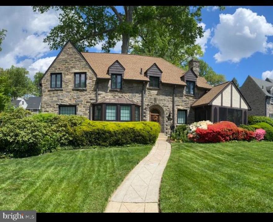 Just minutes from Center City Philadelphia, nestled among the sidewalk-lined lamppost-lit Hallmark movie-esque community of Aronimink Estates in Drexel Hill.  This updated 1930 Stone Tudor home is ready for its new owner! The gorgeous stone arched front entryway leads to the open foyer with hardwood floors that flow into the arched entryways leading into the living room and dining room. The expansive  living room features a gas fireplace with stone surround and access to the screened in front porch. The spacious dining room boasts an abundance of natural light and a chandelier, the perfect spot for gathering. with family and friends. Adjacent to the dining room is a sizable room with built-in bookshelves, making it an ideal spot for an office, playroom or a 5th bedroom.  The kitchen features an arched entryway leading into a cozy cafe style nook adorned with a chandelier and a serene view of the backyard. A brand new SmartThings Electric Range (controlled via wifi w/app), dishwasher, 1 year old refrigerator/freezer and garbage disposal, complete the appliances. A half bathroom and mud room with access to the backyard and the basement complete the first floor. The backyard features a patio, green space and a separate building just waiting for the new owner to give it a purpose. The second floor has 4 bedrooms and 2 full bathrooms. The primary bedroom has a full bathroom as well as  chandelier. The primary bedroom also has access to an additional bedroom that could serve as a dressing room, nursery or home gym.  A door in the hallway grants access to a staircase that leads to the attic which has a huge built-in cedar closet and ample room for storage. Additional features include: a separate building in the rear of the property, a private driveway with plenty of off street parking, central air, radiator heat with 14 custom radiator covers, 200 amp electric, gas fireplace, waterproofed basement with french drain and sump pump (2019), 14 Custom Renewal by Andersen windows - warranty (2020), brand new architectural shingle roof with GAF warranty (2023), original hardwood floors, original wood doors with glass door knobs/hardware. outdoor up lighting on front of house, and mature landscape designed to bloom throughout the year. Don't hesitate to schedule your appointment, this beautiful home has wonderful features and is in a fabulous location! An easy commute to Center City Philadelphia and the Philadelphia International Airport, 20 minutes to Amtrak at  30th Street Station and walkable to Septa bus and trolley lines.  This location is also in the center of meds and eds!!! Close to Children's Hospital, Hospital of the University of Pennsylvania, Jefferson Hospital, Main Line Health facilities and Temple Hospital and surrounded by many distinguished schools and universities: UPenn, Bryn Mawr, Haverford, Villanova, St. Joseph's, Drexel, Temple, and many more! Showings will start Thursday, January 16th.