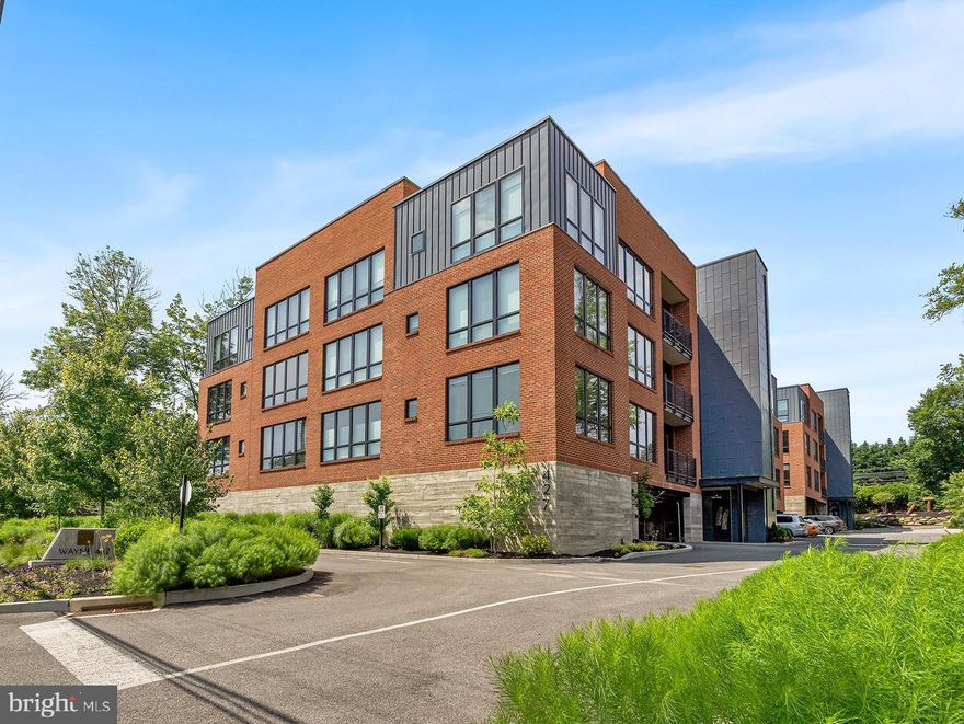Upscale Luxury and elegance converge at Wayne 427, this 3-year-young condominium is a quick walk to the heart of downtown Wayne’s bustling activity and train. This stunning 2-bedroom, 2.5-bath residence offers 1,880 sqft of designer living space, an abundance of sleek high-end finishes, state-of-the-art technology, and amenities, including wide plank oak hardwood floors, soaring ceilings, a private balcony, and oversized windows that frame tranquil tree-top views. The open-concept layout is anchored by a sophisticated living and dining area, complete with a stunning gas fireplace featuring a dramatic custom floor-to-ceiling marble surround, designer light fixtures, and automatic shades. The chef’s kitchen is a showpiece, boasting an extended waterfall edge quartz island with seating for 4, designer backsplash, custom cabinetry, floating shelves, and premium Bosch stainless steel appliances, gas 30” 5 burner cooktop, a Range hood and XO wine fridge—perfect for entertaining in style. Off the kitchen glass French doors open onto your own private balcony overlooking the tree tops.
The expansive primary suite includes a custom outfitted walk-in closet and a spa-inspired bath with a double vanity, radiant heated floors, a soaking tub and frameless glass-enclosed marble shower. A second en suite bedroom with corner windows provides flexible space for guests or a home office, this bedroom has a custom outfitted closet and a luxurious bath. 
This chic condo is accessed through keyless entry, where you are welcomed into a beautifully appointed lobby that sets the stage for this unique luxury building and the common spaces that are designer finished, featuring large windows and tall ceilings. Enjoy modern conveniences like secure electronic entry, two deeded garage parking spaces, exclusive access to building amenities including a fitness center, a serene garden courtyard, a green roof, a dog run and beautiful plantings all along the property, and each unit has its own storage unit, and there is ample guest parking.
All just steps from Wayne’s premier dining, shopping, train station, and located in the award-winning Radnor School District—this is maintenance free elevated Main Line living at its finest.