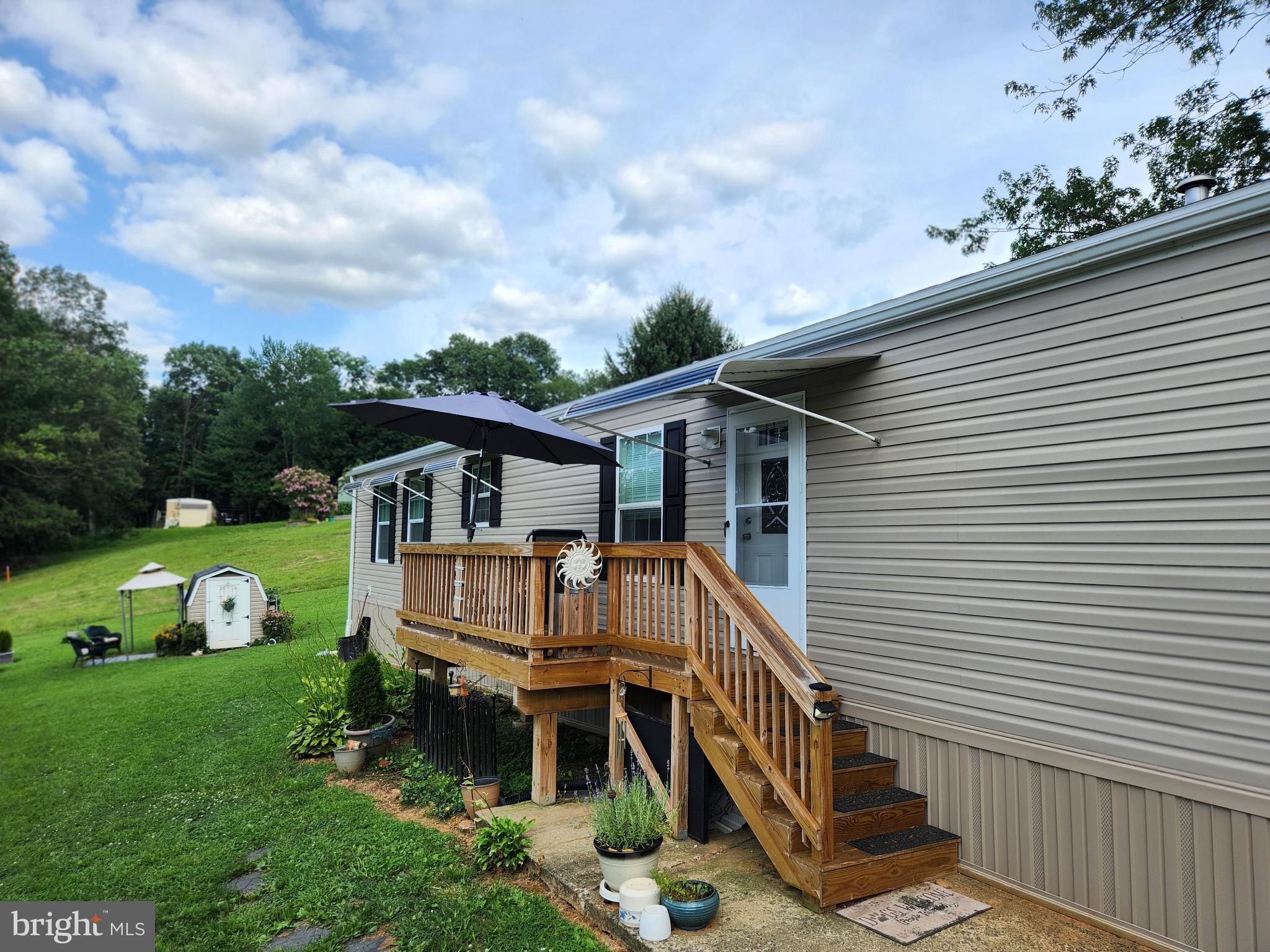 Like new, but better! Beautiful open floor plan home with all of the upgrades in quiet country setting. Get all of the maintenance free benefits of a new home without having to wait on a contractor to add the extras. Farmhouse sink, deck, awnings over front door and windows, walk in shower, new shed and wider doorways. Large kitchen with tons of cabinet space, stainless steel appliances and gas range. Primary bedroom has 2 closets and en suite with walk in tub. Established lot with large trees, flowering bushes, and vegetable garden.