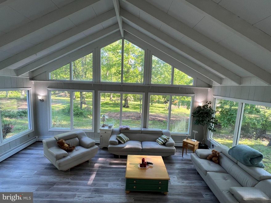 Updated Contemporary Home situation wooded acre lot (.93 acre per zillow). Back to farmland in a rural setting yet close to Highway 309, Philadelphia, Interstate I476, I276.  Public Water, with private well garden faucet.  Open kitchen, vaulted family room over look the wooded  backyard with 3 sides tall glass windows.  See to believe.
