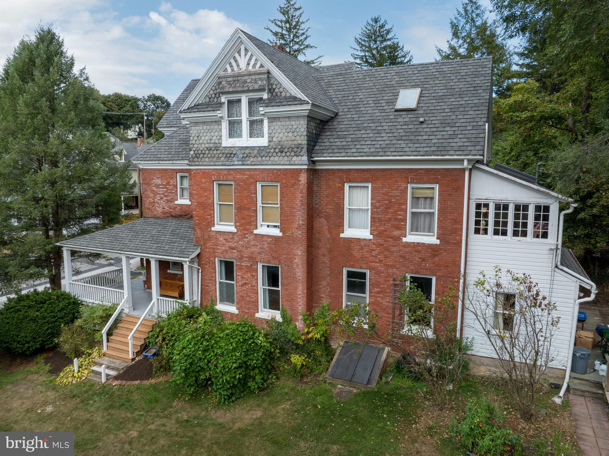 OPEN HOUSE: Sun, Sep 21 12:00 PM - 2:00 PM | Fall in love with 140 East Linn Street in the Historic District of Bellefonte. This brick beauty marries beautiful craftsmanship from an earlier era with modern updates aimed at comfort and efficiency. The main floor features a tiled foyer and a succession of both generous and cozy rooms with tall ceilings, beautiful wood floors, and large windows. Two gas fireplaces are found on this floor, as is a full bath. The eat-in kitchen features a gas range, quality cabinetry and countertops, and an apron-front sink. Conveniently located off the kitchen is a mudroom, with an adjacent full bath. The additional room off the kitchen would work well for a walk-in pantry, office, or storage space. With separate, but flowing spaces, and a generous formal dining room, the main floor is ready for your festive gatherings and cozy evenings at home. Take your time traveling up the main staircase (there are two) to appreciate the intricate woodwork on the banister. The dreamy primary suite features a large bedroom, walk-in closet, luxurious en suite bath, and an adjacent laundry room. Conveniently located, the laundry room has access from both the primary bedroom and the hallway. Two additional bedrooms, another pretty full bath, and a sweet sunroom complete the second floor. Wish you had even more space? Continue up to the partially finished third floor. Three large and sunny rooms, a bonus wood paneled space, and a full bath await you there. Whether you desire large areas for storage or dream of a design project, the third floor is brimming with potential. Additional highlights include a partially fenced backyard, side yard driveway, PEX plumbing, gas furnace, and on-demand hot water. Stately East Linn Street has beautiful Victorian homes, sidewalks, mature trees, and an easy proximity to all that downtown Bellefonte has to offer. Stroll over to the cafes and cute shops, the public library, and lovely Talleyrand Park. Penn State campus and downtown State College are a quick and easy commute away.