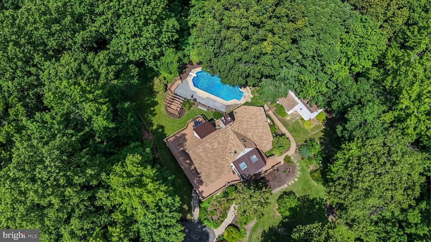 Tucked away on over 3 wooded acres, this private home is surrounded by lush landscaping and extensive hardscaping, offering a setting that’s as scenic as it is serene. Not your typical home, this spacious A-frame beauty is made for those who crave character. Step outside to find multiple newly refinished decks that wrap around the home, perfect for soaking in the peaceful surroundings, or overlooking the large in-ground pool, ideal for summer days at home. Follow the paver steps up to the front door and into the charming breakfast nook, drenched in sunlight and welcoming you into the heart of the home: the kitchen. This space features newly refaced cabinetry, corian countertops, luxury vinyl plank flooring, and ample counter space for prep work or hosting. The adjoining living areas are warm and inviting, with refinished hardwood floors and expansive windows that frame views of the woods. The main level offers two bedrooms and a full bathroom, while upstairs is a generously sized owner's suite with a private balcony. A separate sitting room offers flexibility as a dream walk-in closet or home office. The en-suite bath is beautifully updated with subway tile, a soaking tub, double vanities, and a glass shower. The fully finished basement adds even more living space, complete with rich wood accent walls, a pellet stove, half bath, wet bar, and a pool table, perfect for game nights or cozy evenings in. Additional features include a new well pump (2024), new hot water heater (2024), water softener (2023), roof approximately 15 years old, and windows and doors approximately 10 years old. All this, and just minutes to Route 4 and Route 2 for an easy commute and everyday convenience.