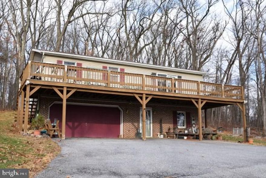 Drive down the lane and enter your little piece of paradise. 3+acres of wooded peaceful land that awaits you and your life in the country while close to major roads and shopping conveniences. Home is cozy with 3 bedrooms, kitchen, & dining area in raised level and a large family room with coal stove in lower level.  Raised deck surrounds sides and front of home. Oversized pole building and small barn add to the charm of this wonderful property!