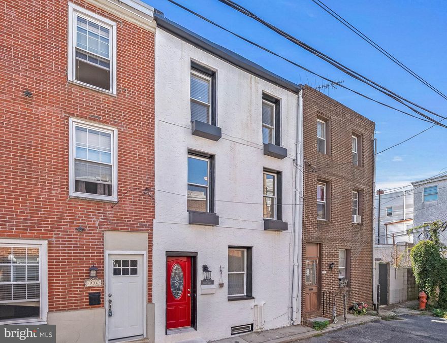 Located in the heart of sought-after Passyunk Square, surrounded by top dining, shopping, and entertainment, you'll find 938 Ernst St. This move-in-ready 3-story home has 2 bedrooms, 1.5 bathrooms, and a finished basement. A quiet, low traffic block leads to the towering facade and vibrant red door. Inside, gleaming hardwood floors stretch across the bright living room, where there's plenty of space to hang out and entertain. An archway opens to the updated kitchen, allowing for an easy flow. More living space and a half bathroom are found in the finished basement, perfect for a gym, home theater, or playroom. Up on the second level, there's a spacious bedroom with a pair of tall windows and an extra-wide bathroom boasting tons of natural light, a distinctive pattern on the floor, and the convenient laundry closet. Topping off the home is a large, bright, and airy second bedroom framed by a soaring pitched ceiling. In addition to everything inside, this prime location earns a Walk Score of 97! Around the corner, lively E Passyunk Ave is lined with top-rated restaurants and local favorites like Pat's & Geno's. The famed 9th St Italian Market is steps away, plus sprawling parks & playgrounds are close. There's also easy access to public transit, Washington Ave, I-95, and South Jersey. Schedule your tour today