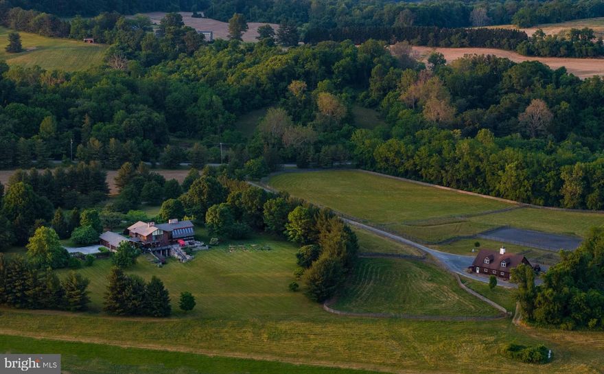 Live authentically. Silverglen Farm. A picturesque oasis. Palpable sense of arrival. Meandering tree lined drive reminds you to slow down and take it all in. Park like grounds that are all yours. Healthy vibrant plantings abound. A supremely livable house… mountain modern with a mid century aesthetic. Light and space abound. Vistas framed from every expanse of glass. Total connection to your surrounds. The changing sky and flourishing earth are ever present. The alchemy of stone, cedar, and glass will sooth you. Balanced and elemental. A magnificent great room designed for joyous gatherings. Dynamic space with strong exposed beams, a series of cloud watching lights punctuate the ceiling, rooted with a natural stone floor, soaring fireplace and bar anchoring the room. Wall of glass flows seamlessly to stone terrace taking in your 57.82 acres of pastoral bliss. Stay healthy on your own hiking trails. Stream on property. Amish built six stall barn with ample area for finishing loft space above. Four fenced paddocks with Nelson waterers. Stalls have a mattress system in place… large riding ring with stone dust and crumb rubber footing… ample room to expand pastures if desired… bring your animals. Barn has separate well and septic. Inspiring cooks culinary space… create and savor on one of your many outdoor spaces. Organic apple and peach orchard. Fig trees. A true pollinator farm as the seller is a beekeeper. Native plantings. The deck house of all deck houses. The spaces are flexible to meet your needs and visions.  Entire wing on the first floor serves as optimal work from home space and or two very private guest suites, one w separate access. Fully finished lower level with additional great room and incredible stone fireplace.  Wall of glass doors for easy access to the great outdoors. A plethora of possibilities. The space that is currently used as the primary suite is on the second floor, a lodge style sanctuary with indulgent dressing, luxe bath, fireplace, terrace, and views that go the distance. Lutron lighting, Wagner roof 1 year old, automatic gate, solar powered remote control skylight blinds, Verizon LTE broadband internet. Subject to conservation easement. See attached MET documents an Agriculture addenda. Cultivate your existence. Art of uniting human and home.