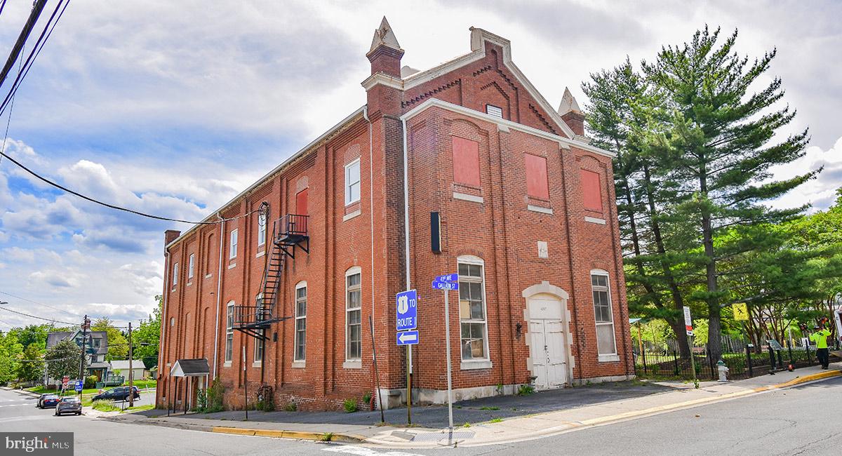 For Lease: Former Mount Hermon Lodge ballroom at 4207 Gallatin Street. From its construction in 1893 and through the 1900s, the Mount Hermon Lodge ballroom was a central gathering space for generations of its members. Now the space is ready to be reactivated with a new use for the Hyattsville community of the 21st century. A local developer is preserving the Lodge property, reconfiguring most of the building for residential use and offering the distinctive former ballroom for lease to a commercial tenant. NAC zoning allows a myriad of commercial uses, including retail or office, art gallery, cultural facility, dance or yoga studio, recreational or entertainment establishment, and day care. Ownership will consider food and beverage uses with light infrastructure requirements. Fronting prominently on the corner of Gallatin and 43rd streets, the 2,072 SF unit features 16’10” high ceilings and six 10’11” high windows. 4207 Gallatin Street is located two blocks from Baltimore Avenue/Route 1 in Hyattsville’s vibrant SoHy arts district, in a Maryland Sustainable Community that qualifies users for various tax credits and incentives. The developer can deliver the unit built to suit the needs of the incoming tenant.