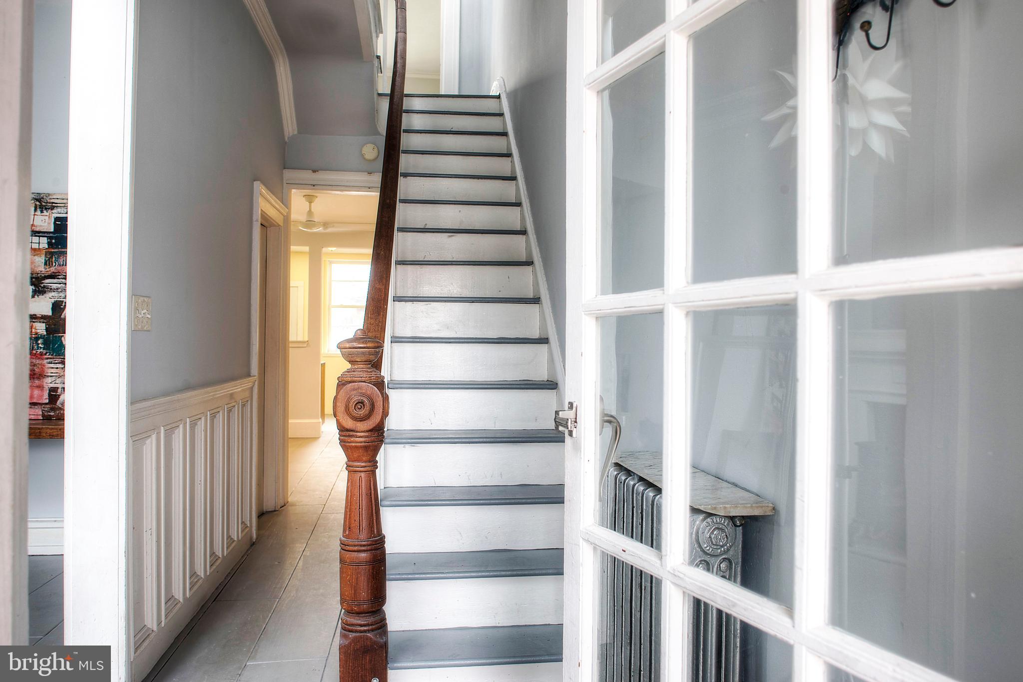 Charming 3-story Victorian style townhouse facing Hawthorne Park in the Bella Vista/Hawthorne neighborhood. It has 3 bedrooms, 3.5 baths, a home office, and a large roof deck. The rooms all have a grand scale with high ceilings and lots of windows. The first floor has a large living room with a gas stove fireplace, half bath and open floor plan dining room and kitchen. There is a lovely tree-lined brick patio off the kitchen with a separate trash and storage area. The second floor has two bedrooms and two full baths. The rear bedroom has two windows and a set of French doors overlooking the patio. The third floor has an en-suite primary bedroom, full bath, and a home office space. There is a large newly rebuilt roof deck off the rear of the third floor. The basement has a utility and storage room with a full-sized washer and dryer. The rear of the basement has a finished bonus room that can be used as an office, den, gym, or children’s playroom. Beautiful Hawthorne Park is across the street and the Italian Market is just a few blocks away. There are also grocery stores on South Street and Washington Avenue. There is ample street parking due to the park and lots of public transportation options. The home has a 96 Walk Score and an 89 Bike Score. There are several day care options within a few blocks and multiple gym options nearby. The local high school, Academy at Palumbo, is a block away.