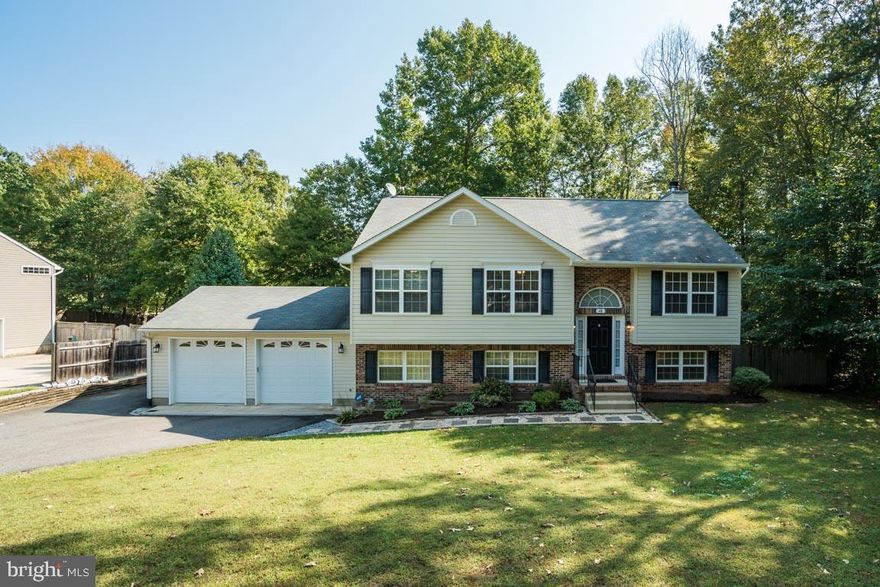 Move in time for the Holidays! Country living just minutes from everything - schools, shopping, commuter lots! No HOA! Clean, light & bright and ready for a new home owner! Set off road for a generous front lawn, perfect for yard games or hosting tent parties. Home backs to woods for serene views from 12x20 deck with a fenced rear yard! Main level offers Owner's Suite has large walk-in closet! Owner's Bath has Soaking Tub/Shower & double Vanity! 2 additional large bedrooms and Hall Bath! Open Vaulted Ceilings on Main Level! Kitchen, Living Room & Dining Room ! Lower Level opens to spacious Family Room with Wood Burning Fireplace, additional Guest Room/Office, Half Bath, Laundry Room and walk-out to 12x18 Patio! 460 sq/ft Bonus Room on lower level is partially finished (former 2 car garage) which also has a walk-out! Newer 2 car garage (22x26) added with auto openers! Additional features, Custom Wood Blinds, Master Suite w/WIC, Master Bath w/double vanities, garden tub/shower, Owner Improvements include Deck, Patio, 2 car garage, Paved Driveway, Hardscaping, Heat Pump (HVAC) replaced in 2017, Well Pump, Bonus Paved Parking Space on side of Home. School buses conveniently stop near end of driveway. <1 mile to water access, 1.5 miles from convenience stores/gas station/post office, major shopping area within 8 miles (Stafford), 10 miles from I-95/commuter lot, and 15 miles to Fredericksburg. Desirable for employees at Quantico MCB (15 mi to main gate, 10 miles to back gate (Onville Rd)) or Fort Belvoir (35 mi to gate). Military owner commuted to Pentagon (45 mi).