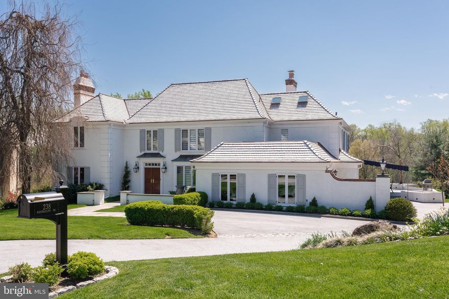Welcome to 238 Ravenscliff, a stunning contemporary executive residence nestled in the coveted locale of Wayne, PA. This elegant home boasts a generous 5473 square feet of interior living space as measured by a Matterport scan floor plan. The home  sits on a picturesque lot spanning over 1/2 acre in a beautiful, mature, and welcoming neighborhood.
As you approach the house, a new flagstone-paved promenade and gas lanterns greet you. Splendid gardens and a private entry court set the tone for the home’s inner splendor.
Upon entering, you are greeted by a seamless blend of sophistication and modern design. The interior boasts luxurious details, open space, and abundant windows that bathe it in natural light, fostering a welcoming atmosphere.
The main level features an expansive living space with a towering two-sided fireplace, a stylish bar, and panoramic views, ideal for hosting grand gatherings and moments of repose. 
The gourmet kitchen is a culinary masterpiece, equipped with top-of-the-line appliances and a stylish marble island, ideal for casual dining and entertaining. The primary bedroom is a luxurious retreat with an en-suite bathroom with a soaking tub, large shower, and touch light mirrors. The generous closet is complete with abundant storage solutions.
Each additional bedroom features a private en-suite bathroom, ensuring comfort and privacy for family and guests.
Step outside to the expansive deck, where you can savor al fresco dining or simply unwind while enjoying the picturesque views. During peak sunlight, seek shelter beneath the stunning new awning, which provides a perfect vantage point for enjoying breathtaking western sunsets.
In the chilly winter season, unwind in front of one of the two inviting fireplaces with a captivating book. The home also includes a fully finished lower level, boasting a full bar, movie theater, gym, craft room, additional storage, and the potential for a fourth bedroom.
With the security of a recently installed roof, water heater, boiler, and windows, this home presents a lifestyle of luxury and sophistication. Don't let this opportunity slip by to make this exceptional property your new home.
