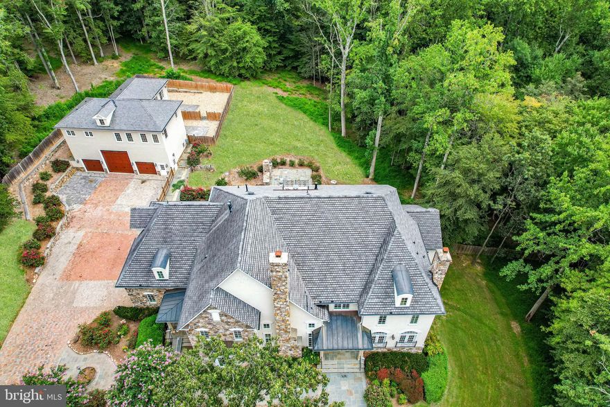 FIRST TIME EVER OPEN HOUSE - SUNDAY MAY 17TH FROM 1-4PM.  TAKE THIS OPPORTUNITY TO PEEK INSIDE ONE OF CLIFTON'S MOST PRESTIGIOUS HOMES.  IDEAL FOR THOSE DESIRING A MULTI-GENERATIONAL LIVING OR CAR ENTHUSIASTS NEEDING MULTIPLE GARAGES.  Offering the utmost in privacy and security, this 5.63 acre gated compound is fully fenced and provides a level of comfort for those desiring a secure and peaceful environment.  This luxurious estate features the main residence with embassy sized spaces and a carriage house with 2 bedrooms and 2.5 baths that would be ideal for multi-generational or staff living.   Fully renovated in 2020 with premium materials and high quality craftsmanship the estate boasts a total of 8 bedrooms, 13 baths, an elevator and 5 oversized garage bays with a 6th oversized RV bay offering  approximately 17,000sf of heated and cooled space.  This exceptional residence has it all and is located in the historic and charming town of Clifton,  a quick 40 minute drive to DC, or 20 minutes to Dulles International or Manassas Airports.    

Prepare to be impressed by the gracious curb appeal as you enter through the gates and  proceed up the brick paver driveway to the stone accented impressive main residence with 6 bedrooms, 8 baths, a side load 3 car garage and an elevator that services all 4 floors.  Walk up the storybook slate walkway, past the side porch and onto the veranda, and enter this breathtaking home through double leaded glass doors.  The majestic grand foyer features vaulted ceilings, travertine floors and exquisite millwork.  The main level features soaring ceilings, multiple fireplaces with custom mosaic surrounds and wonderful formal and informal spaces for entertaining with an exquisite living room and dining room with crystal chandeliers, an inviting family room with walls of atrium windows, a music room, a handsome wood paneled library plus a sunroom.  
The heart of the home is the gourmet kitchen with double island, expansive custom cherry cabinetry with inlaid glass accent cabinets, high end Sub Zero and Viking appliances, walk-in pantry and ample eat-in dining with a door to the deck and outdoor kitchen.  
The upper levels house the opulent primary suite with sitting room, fireplace, coffee bar, dressing room with huge walk-in closet and a luxurious spa resort bath.  Four additional bedrooms all with en suite baths and a bedroom level laundry complete the upper levels.  
The incredible 3500sf walk out lower level with 10 foot ceilings is light and bright with a French door and windows for enhanced natural light.  This is the perfect spot for entertaining with an upscale bar/billiards room with copper ceiling, private professional home theatre with excellent sound distribution, climate controlled wine room, gym, a guest suite with full bath, powder room and extra storage/flex space.  The lower level features a walk out to extensive decking and an inviting patio with a massive stone fireplace.    
The secondary residence is above the detached carriage house with a beautifully appointed 2 bedroom, 2.5 bath apartment with travertine flooring, crown molding, spa-like baths and a kitchen with walk-in pantry.  The outdoor spaces are as equally impressive as the interior spaces with 5.63 acres of fully fenced privacy, multiple patios and decks and 2 separate fenced yard areas off the detached carriage house and wonderful trails to explore the nature that abounds.   
Located on a quiet, private cul-de-sac off Yates Ford, and just one mile to the Clifton Historic District with quaint shops and trendy restaurants, explore the scenic trails, play golf at one of three area courses or sip wine at the nearby Paradise Springs Winery.   Minutes to 66, Fairfax County Parkway, Routes 29 and 28, this spectacular residence is an easy commute to Dulles Airport, DC and the Tech Corridor. Note - square footage includes main house and separate detached garage with 2 bedroom apartment in carriage house.
