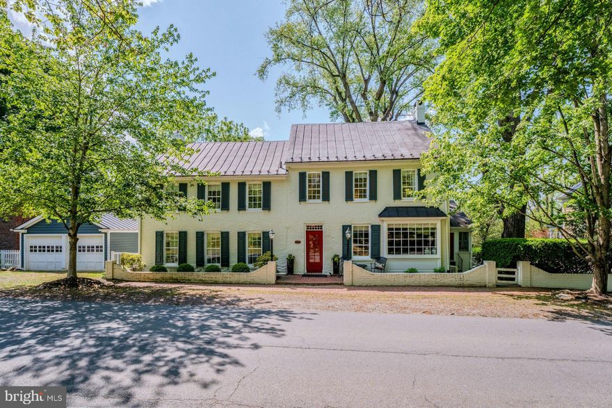 A rare opportunity to own one of the Village of Waterford’s landmark historic homes. Known as the Ephraim Schooley House, circa 1825, this beautifully restored property sits on nearly 4 acres in the heart of the Historic District, backing directly to the permanently protected 144-acre Phillips Farm. Properties with this amount of land, privacy, and uninterrupted pastoral views within the village are exceptionally hard to find.
The home offers approximately 4,398 square feet across three finished levels with 4 bedrooms, 3 full baths, a detached 2-car garage, and extensive off-street parking an uncommon feature in Waterford. The current owners have completed substantial renovations and updates while preserving the home’s historic character. The newly renovated kitchen features custom cabinetry, premium appliances, skylights, a butler’s pantry, and an oversized mudroom filled with natural light. Living spaces are warm and inviting, including a large great room with fireplace, wet bar, oversized windows, and French doors opening to the outdoor living areas. A formal dining room, family room, and sunroom with radiant heated floors complete the main level.
Upstairs, the primary suite includes cathedral ceilings, a fireplace, walk-in closets, and a spacious bath with double vanities, all overlooking the surrounding countryside. Three additional bedrooms and two full baths complete the upper level, while the finished third floor provides flexible bonus space, office space, or additional storage.
One of the property’s most special features is the setting itself. The grounds offer exceptional privacy with mature landscaping, specimen plantings, fenced pasture areas, a garden shed, a peaceful water feature with waterfall, stone patio and custom pergola. Additional features include a high-yield well, public sewer, brand-new AC system, portable generator hookup, and numerous recent system and cosmetic improvements throughout.