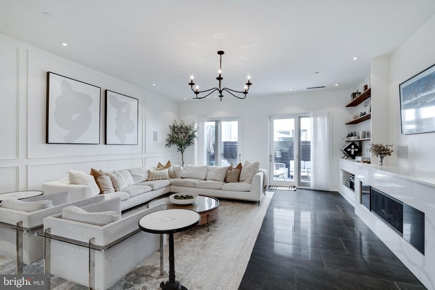 Experience unmatched luxury living in Northern Liberties with this approximately 4,500 square foot exquisite contemporary townhome. This home features expertly designed interiors, three expansive levels of outdoor living space, and the practicality of a two-car attached garage, establishing itself as the epitome of high-end urban living in one of Philadelphia's most dynamic neighborhoods. Enter through the impressive first-floor foyer, complete with a chic powder room, a handy coat closet, garage access, and a sunlit home office. Venture down to the full basement lower level where a flexible space awaits, perfect for a family room, play area, gym, or home theater, enhanced with an additional powder room and a sophisticated wet bar. Navigate upwards via the elegant iron and walnut staircase or use the private elevator to reach the second-floor entertainment space. This area features radiant heated floors, over 20 ft of width, high ceilings accented by recessed and designer lighting, custom wainscotting and built-in shelving surrounding the linear gas fireplace. The state-of-the-art kitchen on this level boasts high-end stone countertops, custom Italian lacquer cabinetry, and top-tier SubZero and Wolf appliances. The large waterfall island doubles as a breakfast bar, perfect for informal dining, while the nearby dining area is ideal for more formal occasions. The third-floor houses two beautifully appointed secondary suites with ample closet space, luxurious en suite bathrooms, and easy access to a large laundry room. Discover the pinnacle of indulgence in the owner’s full-floor retreat, which includes two custom walk-in closets and a spacious king-size bedroom. Relax in the spa-like bathroom with a deluxe Kohler soaking tub, a large glass rain shower, dual vanities, and heated marble floors. Enjoy the private balcony or continue up to the spectacular roof decks, which offer stunning city views and feature a fully equipped summer kitchen with plenty of space to relax and enjoy with the family. Approximately 4 years remain on the tax abatement.