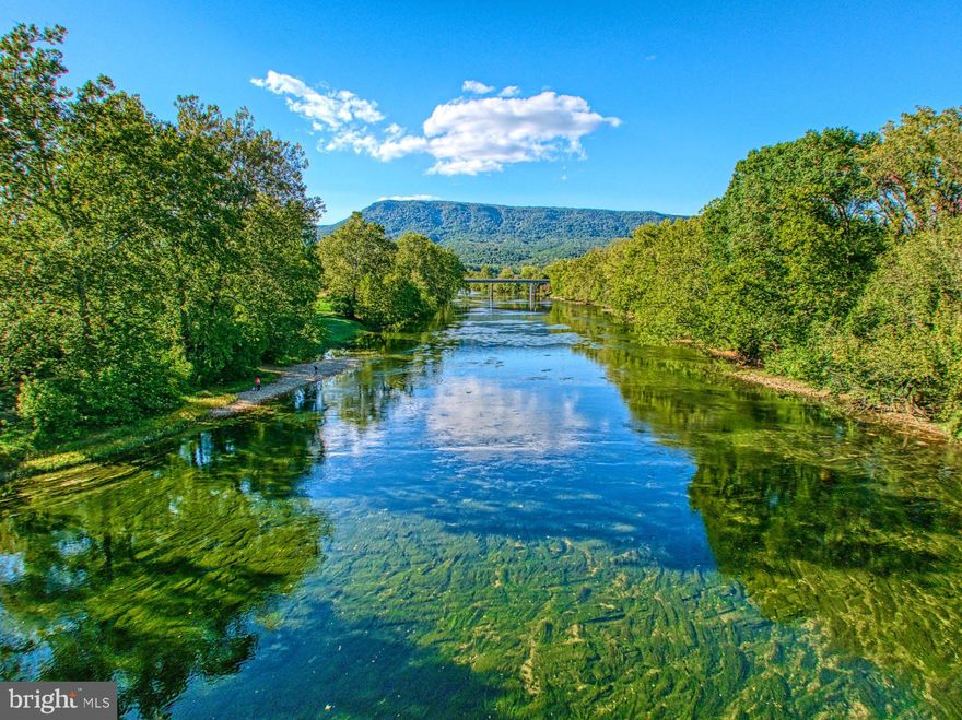 Fly fishing or kayaking, what to do on the river today?  Or the rock wall in your own quarry? 25 acres along the banks of the Shenandoah, remnants of the old roadbed to a once upon a time bridge is still there in the lower field.  The chimney of the old smokehouse still remains and anchors the now patio, what a great spot for grilling and stargazing!  The foundation of the old bank barn, visible in the distance, lines up with the direction of the old roadbed.  Stone from the quarry was used for the second fireplace inside the cabin portion of the farm, and before that the quarry was a source for the Blue Ridge Parkway.  A piece of history, an early settlement grown into a family farm to eventually become a multi-family retreat.  Only 30 minutes from Harrisonburg and JMU and 1.5 hours by car from the DC suburbs (or fly into Luray Airport on a private plane).  Come check it out!  It could be your history in the making!
