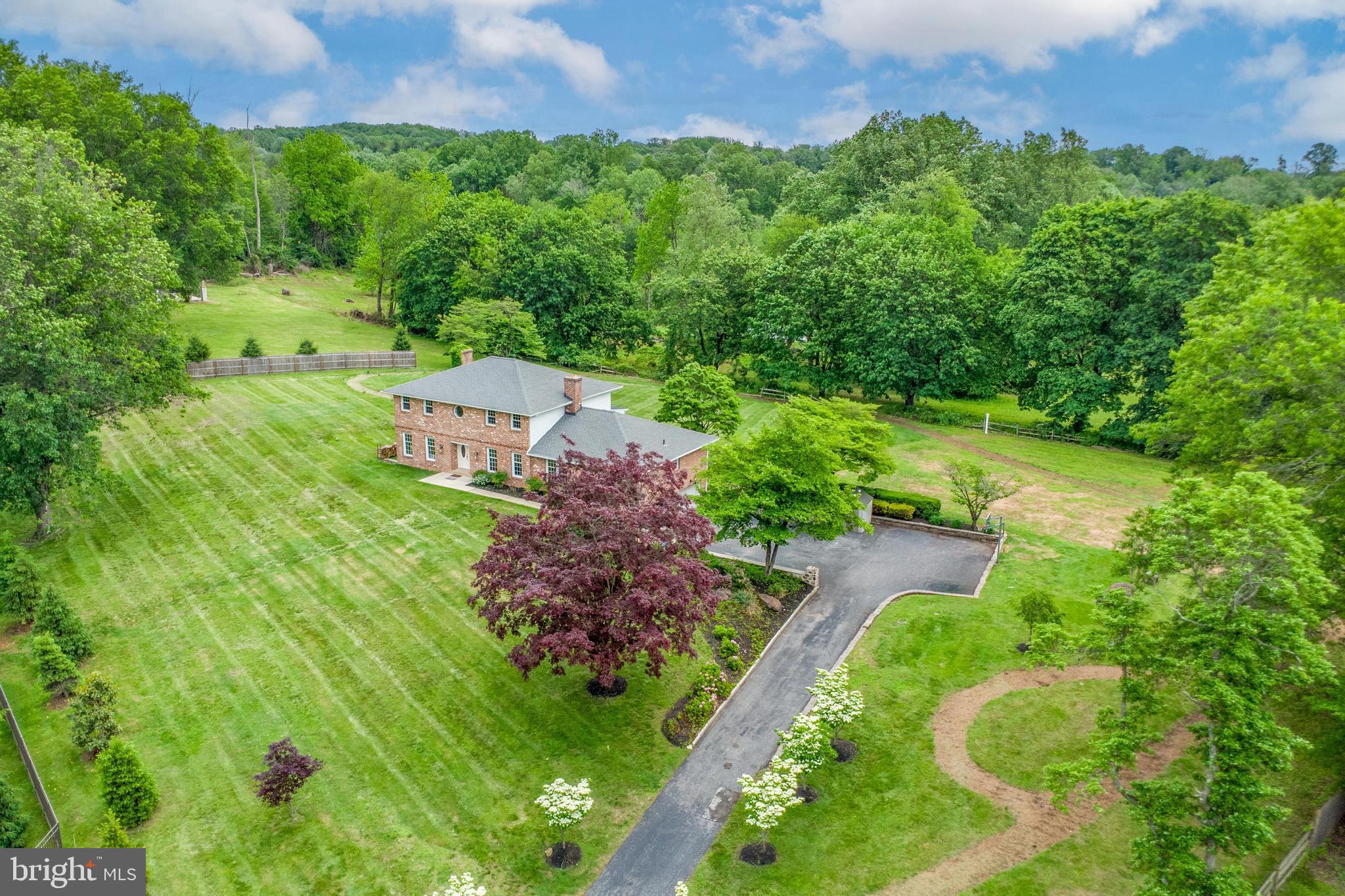 Tucked away on nearly two private acres in Thornbury Township, this property has been renovated throughout and offers a rare blend of natural beauty, thoughtful upgrades, and versatile living. A long, tree-lined driveway leads to a classic brick colonial surrounded by mature landscaping, flowering trees, and a walking path that winds through the yard. The expansive outdoor space includes a patio perfect for entertaining, lush open lawn, and even a powered chicken coop for those seeking a modern homestead touch. It’s the kind of serene setting that feels miles away—yet is close to everything.
Inside, the home offers an ideal setup for multi-generational living. The first floor is complete with a full in-law suite featuring two bedrooms, its own kitchen, living room with fireplace, private laundry, and a beautifully remodeled bathroom.
The bright white main kitchen has been completely transformed with high-end appliances, new cabinetry, countertops, backsplash and lighting—blending function and design seamlessly. The sunroom, attached to the kitchen was rebuilt from the ground up and is flooded with natural light, a perfect spot for morning coffee or quiet evenings. Off the sunroom enjoy the patio providing an indoor, outdoor dining experience. A formal dining room and sitting room previously use as a gym space with mirrored wall complete the main level.
Upstairs there is a large master suite featuring a custom closet and luxurious, sun drenched en suite bathroom. Two additional bedrooms upstairs complete this level, with the third bedroom currently being utilized as a home office with glass front cabinets, full bar and stone countertop. New luxurious thick carpet just installed in two bedrooms upstairs with hard flooring in the office area.
Hardwood floors, three fireplaces, a sweeping staircase, and solid-core interior doors add to the home’s charm and quality of construction throughout. The fully finished basement offers a full wet bar, defined media space, luxury vinyl plank flooring and stylish finishes.
Every inch has been thoughtfully updated—from HVAC and window treatments to landscaping and well systems making this property a true turnkey retreat. Schedule your showing today!