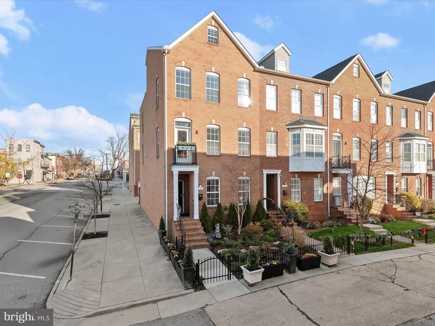 Introducing this stunning end-unit townhome, offering four levels of luxurious living with three bedrooms, three full and two half bathrooms. Complete with a private two-car garage, an additional driveway spot, and a breathtaking rooftop terrace with panoramic city views, this home has it all! Perfectly situated at the corner of a one-way street in the heart of Canton, this all-brick home is flooded with natural light from 22 oversized windows, enhanced by tall ceilings, ¾" solid oak hardwood floors, and elegant crown molding throughout. The professionally landscaped front garden is designed as a butterfly habitat, featuring no-maintenance perennial flowers and evergreens, all enclosed by a private gated iron fence. Step inside through the welcoming foyer or the rear-loading garage. The entry level includes a bedroom suite with a private bathroom featuring a floor-to-ceiling tiled shower and tub. Upstairs, the main level’s open-concept kitchen and dining area provide a flexible space to fit your lifestyle, highlighted by a gas fireplace. The kitchen boasts granite countertops, an accent tile backsplash, 42” cabinets with underlighting, a pantry, and a center island with a breakfast bar for casual meals. The stainless steel appliances include double wall ovens and a gas cooktop. The inviting living room features a small balcony, perfect for fresh air and relaxation. A half bathroom completes this level. Ascend upstairs, where the primary bedroom suite awaits, featuring a spacious walk-in closet with custom organizers and a spa-like ensuite bathroom with a dual sink vanity, a Jacuzzi tub, and a large walk-in shower with body jets and a built-in bench. Down the hall, the second bedroom has an adjoining full bathroom with a jetted tub and shower, while the laundry closet with a stacked washer and dryer adds convenience. The top level is designed for entertaining! A loft with a wet bar, sink, and beverage fridge opens to the rooftop terrace. This level also includes a dining area, a versatile office/lounge nook, and a half bathroom. Alternatively, this level provides flexibility and could be used as a fourth bedroom. Step outside to the rooftop terrace with panoramic views, complete with a pergola, fire pit, and a custom water fountain with lighting and plants. Additional features include a gas hookup line for a grill, a hose bib, and composite decking. Enjoy stunning sunsets, fireworks, and air show flyovers from the comfort of home, with views stretching from the hilltop to the harbor, Fort McHenry, and the city skyline. The oversized 20’ x 19’ two-car garage offers extra storage with two closets, and the one-car driveway ensures you never have to worry about parking. Located in the vibrant, pedestrian-friendly Canton neighborhood, this home is around the corner from a great variety of restaurants, pubs, parks, shopping, grocery stores, gyms, and so much more.