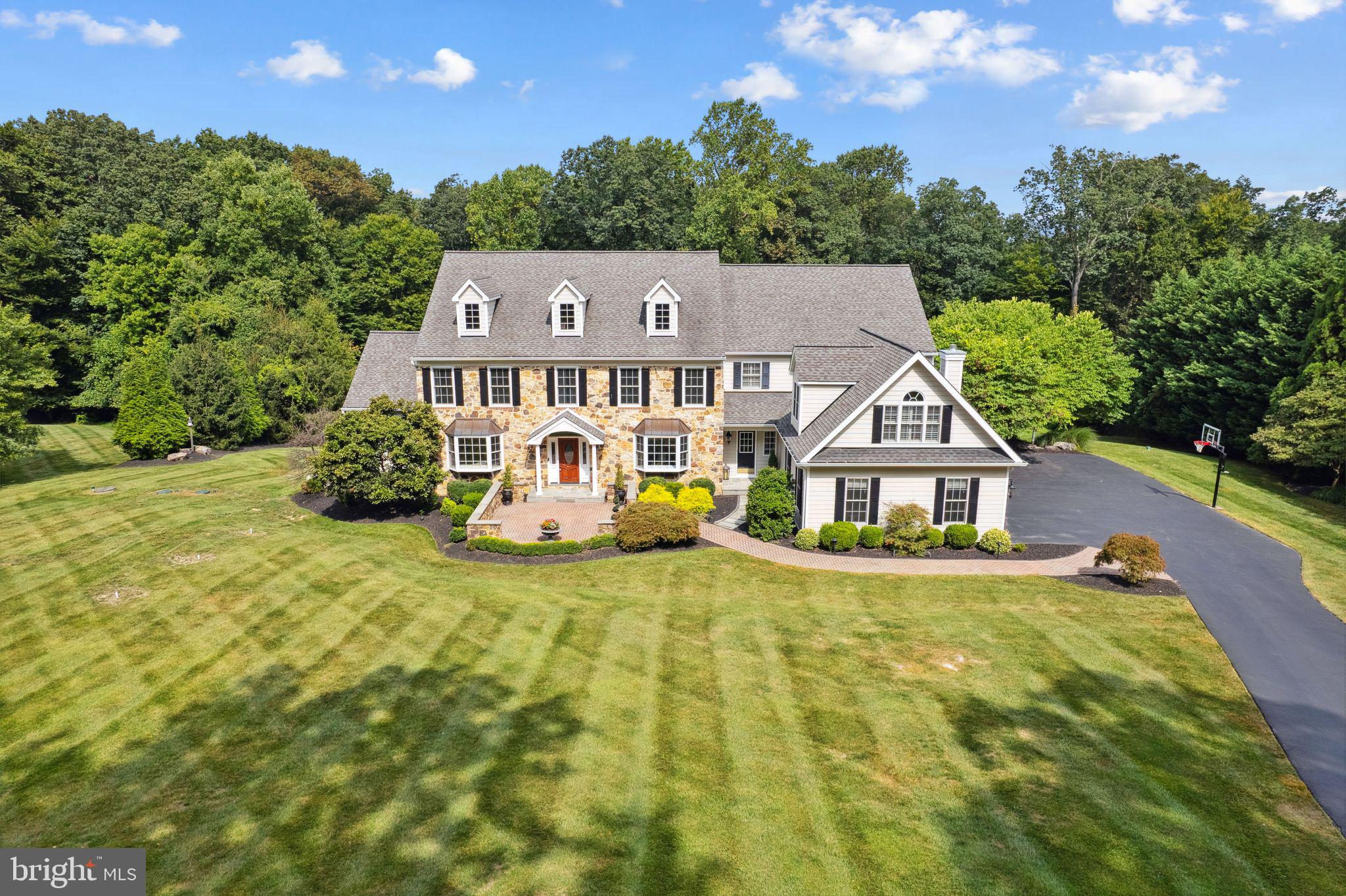 Malvern stunner with almost 6 acres of land on a private road that leads into a quiet, secluded cul-de-sac in Charlestown Township. New tax assessment for 2025 - cost savings of $6,000+ yearly! This breathtaking 5-bedroom Colonial offers a professionally epoxied 4-car garage, a custom, built-in mudroom for convenient storage off the garage, a beautifully updated eat-in kitchen with stainless steel Wolf appliances and a huge Sub-Zero fridge, a 1000+ square foot finished basement with space for an in-law suite or home gym, and a main level perfect for entertaining with crystal chandeliers, a sunroom filled with natural light, a formal dining and sitting room, and an over-sized family room with a gas fireplace!
As you enter through the grand foyer, hardwood floors, intricate millwork, and crown molding set a refined tone. Host memorable gatherings in the sophisticated dining room, complete with a tray ceiling, crystal chandelier, and ambient wall sconces. The adjacent butler’s pantry and walk-through bar ensure effortless entertaining, while the gourmet eat-in kitchen delights with bright cabinetry, quartz countertops, and high-end stainless steel appliances. The large island offers both additional prep space and seating, and the dining area seamlessly transitions to the impressive outdoor patio with built-in gas grill via sliding doors.
The inviting family room, featuring a vaulted ceiling and a striking fireplace with a wood mantel, serves as the heart of the home—a perfect retreat for cozy gatherings. This level also includes two convenient half baths and a dedicated home office with built-in shelving.
Up the sweeping staircase, the expansive primary suite provides a true sanctuary with a detailed tray ceiling, a serene sitting room complete with built-ins and a gas fireplace, two spacious walk-in closets, and two exquisitely designed full bathrooms. Four additional bedrooms, each offering ample closet space, and two well-appointed full bathrooms complete this level.
The finished basement is an entertainer’s dream, featuring a kitchen/bar, a spacious family/game room with a fireplace, and a full bathroom with a shower/tub combo. Sliding doors lead to the outdoors, where an expansive patio with a built-in grill awaits—ideal for al fresco dining and outdoor gatherings. Stairs leading from the basement to the 4-car garage add to the home’s functionality.
Set on almost 6 acres of professionally landscaped grounds, this residence offers a private oasis for outdoor enjoyment and relaxation. A short walk brings you to Brightside Farm Park to enjoy hiking and walking on paved paths through the woods. Recent 2024 updates (totaling $300,000) include full stucco remediation and installation of Hardie board with a transferable 5-year warranty, new 6-inch gutters, new carpeting, and fresh interior paint, ensuring this home is move-in ready and impeccably maintained.