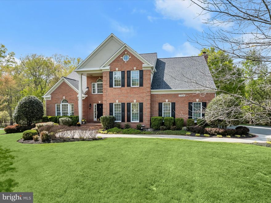 Welcome to 7108 Crabbury Court in Clarksville, MD.  This Winchester home is nestled on a lush flat lot in a vibrant community of Ashleigh Knolls where a compelling sense of place draws you in.   Meticulously manicured, the front lawn and garden beds surround a serpentine slate walk, trimmed in soldier brick that welcomes friends and family to the covered front porch.
Inside, a fresh, clean and light palette is set against rich wood tone floors that create style and beauty. A dramatic two-story foyer opens to Living and Dining Formals with sweeping arched cased openings.  The central Foyer is enhanced by a Palladian window and an open winding stair and is sided by French doors that open into a private study or work at home office with a built-in desk and cabinetry. The rich floor travels throughout the main level with energy that unfolds into the kitchen and breakfast room.

Up to the minute upgrades in the kitchen include a commanding contrast island with trending glass pendants and striking white cabinetry that wrap the perimeter.  Opposite the contrast island, an impressive pantry adds style with upgraded barn doors that follow the vibe established.   The eat-in kitchen invites meals and gatherings inside or choose alfresco dining on the tiered deck overlooking preserved land. As the slider door opens, a pergola defines the first tier, and the second tier offers a larger dining space with a stair to the lower lawn.
The contemporary aesthetic inside is further expressed as the family room joins the open plan with an accent feature wall, gas fireplace with a stone surround, and a wall of windows topped with transoms that bathe the entire space with uplifting sunlight

The open winding stair rises to a spacious upper-level landing with an airy feel, where double doors open into the primary suite introducing an impressive scale and a vaulted ceiling. Space for sitting, two walk-in closets and a linen closet offer every convenience and opportunity to relax, while the spa-like primary bath invites you to treat yourself with a sun-lit luxurious soak at the end of the day. The upper level is completed with three additional bedrooms and a central hall bath that wraps the open stair and landing.

Downstairs, entertain guests in full daylight spaces that are stylish, comfortable and enduring. Gather and lounge in the expansive recreation room and game room or get pumped and exercise with a vibe in the adjacent fitness room. A central walk-out slider door provides indoor and outdoor living spaces to merge while a secondary kitchen, dining space, bedroom and full bathroom could become a private In-law or Au-pair suite.  This very special home captures everything you love and offers endless flexibility for even more. Come home to showcased beauty and energy for a very special lifestyle near great schools, shopping, dining and entertainment.