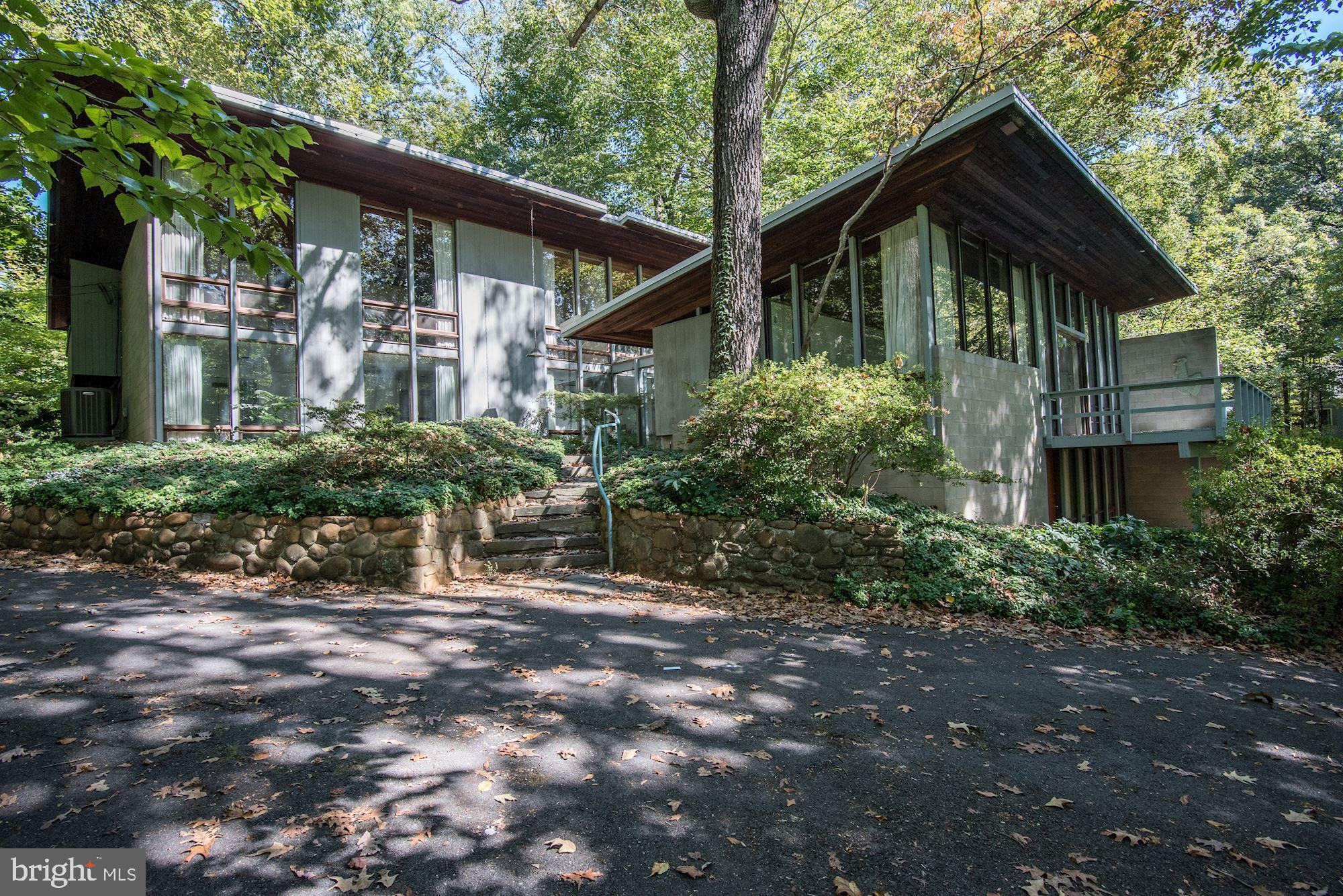 This one-of-a-kind contemporary sited high on a wooded lot is now available for sale. A treehouse effect is created by massive windows in every room, overlooking peaceful views in all directions. The main level provides an atrium entrance hall, sunken great room with fireplace, master suite with bath, dining room, family room, powder room, floating staircase, and access to a glass roofed breakfast room. The upper level has a second master suite, two guest bedrooms, a built-in desk, and a full bath. The lower level provides a nice in-law/au-pair with a private entrance family room, bedroom, full bath, and storage.