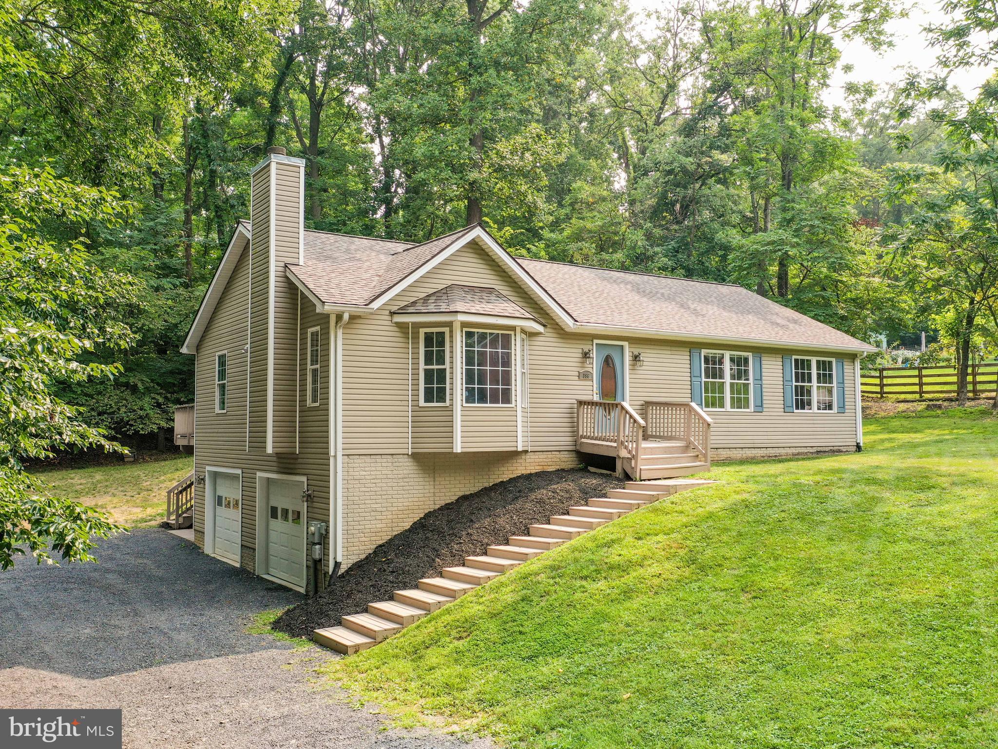 Live outside all summer long and then cozy up to the fireplace in the winter! This move-in-ready, raised ranch home has everything on your wish list! With 3 bedrooms and 3 full bathrooms, it is one-level living at its best with a bonus kitchenette in the finished lower level. Upstairs, enjoy the new paint and carpet throughout. A large eat-in kitchen/dining room opens to the large private deck. The kitchen and dining room both have vaulted ceilings, ceiling fans, and the kitchen boasts stainless steel appliances, breakfast bar/island and a large pantry. The living room, also with vaulted ceilings features a woodburning fireplace and has new carpet. The primary bedroom is generously sized with an ensuite bath, a jetted soaking tub, and a large walk-in closet. Two other bedrooms and a hall bath round out this level. The lower level has a large rec room area with LVP flooring, a full bath, and a kitchenette with a refrigerator, sink, and stacked washer/dryer... possible in-law suite... The over-sized, clean 2-car garage with auto openers and generator hook-up, also has a full-sized washer/dryer accessible from the stamped concrete patio outside. Major updates in the last 3 years include an architectural shingle roof, well pump, HVAC unit, water heater pressure tank, water treatment system, new appliances, and a gorgeous patio underneath the rear deck.
This home is situated on a half an acre lot in Blue Ridge Acres, with a community pool and Shenandoah river access. Comcast/Xfinity cable/internet available.