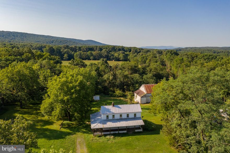 A take a  step back in time in the 1880's original Farmhouse.  This spacious home is 1680 square foot with a huge wrap 49 x 10 x 25  covered wood porch.  Most of the rooms have the original pine flooring.  The living room has a beautiful stone fireplace and the dinning room has a pellet stove.  The house has a total of 9 rooms,  3-6 bedrooms, 1 full bathroom on the main level, main floor laundry room, and a  huge upper level closet. Be sure to see the large walk-up attic for storage.  This mostly level, unrestricted 2 acre lot offers a farmhouse, 34 x 65 barn with wooden timbers and electricity,  5x4 original working  outhouse,  8x18 shed and 6x10 storage shed. Live in this home while you do the renovation work. House will be sold as-is.  Sleepy Creek Wildlife Management Area is located about 1 mile west, the beautiful town of Berkeley Springs is 13.86 miles away and the Virginia line is only a few miles away . Located off a state maintained road.  A true get-away and a must see!