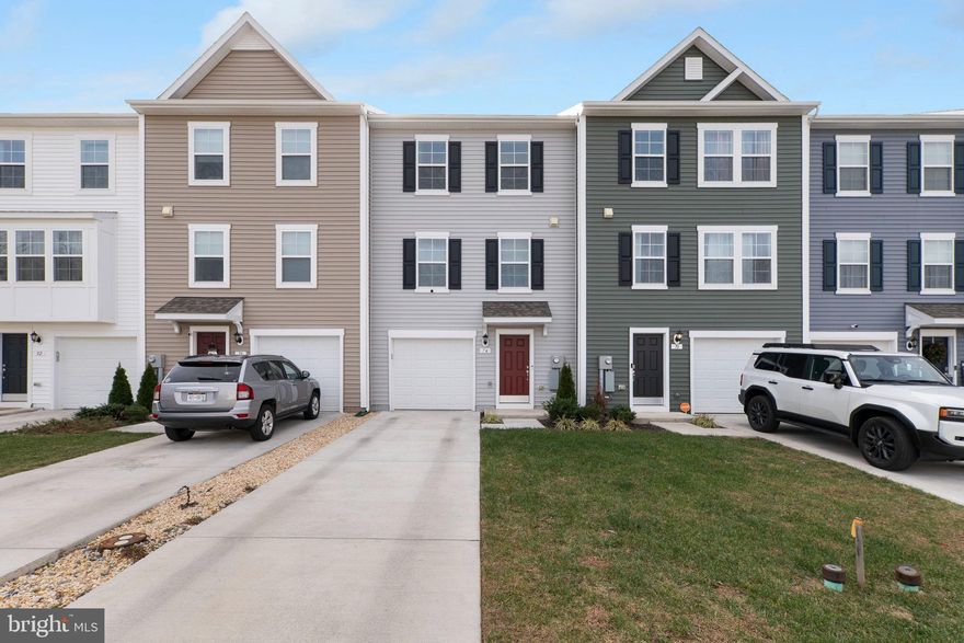 Welcome to 74 Colchester Ct, a beautifully appointed 3-level townhome built in 2023, offering modern design, energy-efficient features, and exceptional convenience. Located in the desirable community of Bunker Hill, this home places you just minutes from Martinsburg, Winchester, and major routes into Northern Virginia—perfect for commuters and anyone seeking easy access to shopping, dining, and everyday necessities.

Step inside to find an inviting layout with luxury vinyl plank flooring throughout the main living spaces and upgraded fixtures, cabinets, and countertops that elevate the home’s contemporary style. The kitchen is equipped with sleek stainless steel appliances and ample upgraded cabinetry, making meal prep and entertaining both effortless and enjoyable.

The upper level features a comfortable primary bedroom complete with a ceiling fan, generous closet space, and access to well-appointed bathrooms with modern finishes. Additional bedrooms provide flexibility for guests, a home office, or hobbies.

The entry level includes a one-car garage that comes pre-wired for an electric vehicle charging station, offering added value and future-ready convenience.

With its nearly new construction, thoughtful upgrades, and ideal location, 74 Colchester Ct is the perfect blend of comfort, style, and practicality. Move-in ready and waiting to welcome you home!