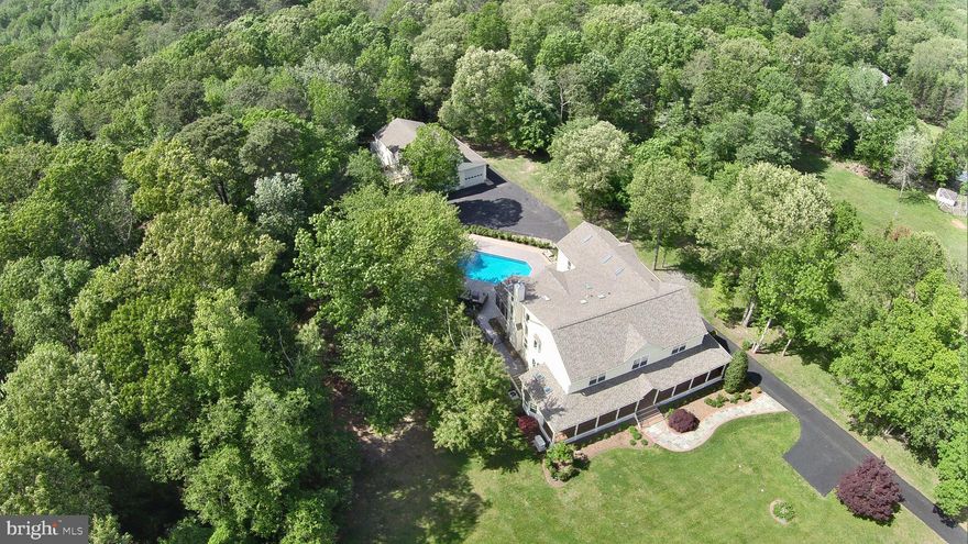 Gorgeous custom built home with over 12,000 square feet combined situated on 2.67 sprawling landscaped acres thoughtfully designed to accommodate multi-generational living. This elegant gated estate is comprised of a 5 bedroom, 5.5 bath modern farmhouse with an additional guest suite with fully appointed kitchenette in the lower level and an expansive detached oversized garage with a three bedroom, one bath apartment. The main house features a large kitchen with stainless steel appliances, granite countertops and ample cabinetry. Oversized family room with second story overlook features gorgeous natural light and stunning fireplace. Elevator with four floor access. Whole house emergency power generator. Laundry on all floors and ample storage areas. Fenced in entertaining area with heated salt water pool, full outdoor heated/AC bath and ample patio/deck space is ideal for entertaining. Two car attached garage with ample parking driveway. 30 x 50 detached garage area with lift, built in workshop, half bath with interior stairs to upper level. 15 x 62 x 12 additional equipment storage area for motorhome, mowers, ATVs, etc. Apartment over garage boasts open floor plan with kitchen, laundry, family room, three bedrooms and one bath perfect for additional income potential. This estate was devised to provide private living for all generations with the ability to enjoy time together and the many amenities. Beautiful country living with easy access to Baltimore, Washington or Annapolis.