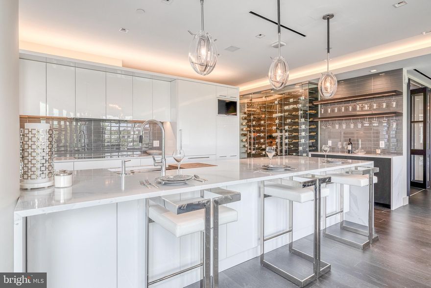 This luxurious condominium is located above Independence Hall and offers a refined living experience. It is the first unit of its type for resale in the prestigious Residences at 500 Walnut and features 3,200 square feet of living space. The unit is turnkey and has been uniquely crafted to provide a one-of-a-kind experience. Upon entering the condominium through double doors, you will be greeted by an impressive foyer with a custom lighting fixture. The open dining and kitchen area is illuminated by panoramic floor-to-ceiling windows, creating a bright and spacious atmosphere. The gourmet kitchen is expertly designed with waterfall edge quartz counters, a breakfast bar, Gaggenau appliances, white lacquered soft-close cabinetry, and a 200+ bottle wine storage case. The dining and living room area features wide-plank hardwood floors, a vented gas fireplace, and custom recessed lighting. From here, you can step out onto a large terrace that overlooks Independence Mall, offering captivating views of historic Philadelphia. The owner's suite is spacious and includes bright windows, terrace access, lofty tray ceilings with recessed lighting, and a walk-in double closet with customized storage. The ensuite bathroom features two oversized vanities, a standing glass-enclosed rain shower, and a Toto washlet toilet. There are also two additional generously sized bedrooms, each with a three-piece bathroom and large closets. In addition to the bedrooms, the condominium includes an entertainment room, home office, hall powder room, laundry room, Lutron lighting and shade system, and ample storage throughout. Developed by the highly esteemed Scannapieco Development Corporation, this exclusive residence offers only 34 units for unmatched privacy and prestige. Residents of this condo at 500 Walnut can enjoy two-car parking in the fully automated parking garage, which includes the country's first induction charging for electric cars. The building also offers world-class amenities such as a full-service concierge and doorman, a Mercedes town car and driver, a guest suite, and a 4,000 square foot treetop terrace overlooking Independence Hall. Located at the corner of 5th and Walnut Streets, this imperial building is conveniently close to the neighborhood's most distinguished restaurants, cafes, boutiques, and major transportation options. Experience extraordinary style, comfort, and convenience in Philadelphia's most sought-after zip code! This condominium is also available for lease at $15,000 per month.