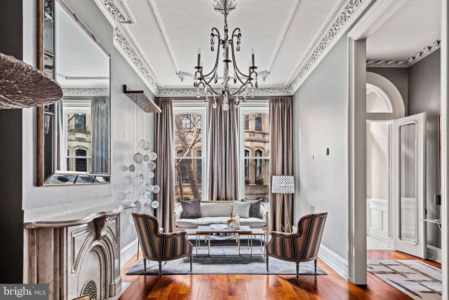 Experience the pinnacle of understated luxury at 2105 Spruce Street, a historic townhouse in the heart of Rittenhouse Square that seamlessly blends timeless charm with modern conveniences. Built in 1865 and holding ties to the Wanamaker family, this distinguished residence presents 5 bedrooms, 5 full bathrooms, and an elevator, ensuring both comfort and accessibility across four levels.

As you step through the front vestibule, the original plaster moldings in the living spaces immediately catch your eye—a nod to the craftsmanship of a bygone era. The first level features a formal living room with a marble mantle, 12+ ft ceilings, and a discreetly tucked powder room. A home office with French pocket doors and original leaded glass windows, along with a spacious mudroom leading to a gated easement and 1-car attached parking, complete this level.

The second level hosts the heart of the home—an impeccably renovated kitchen (2019) with high-end appliances seamlessly integrated into custom cabinetry. A large stone island connects to the dining area, opening to a private deck. A sun-filled family room with a gas fireplace, laundry room, and an additional powder room add to the functionality of this level.

On the third level, discover two bedrooms on the North side with custom outfitted closets and a hall bathroom, while a spacious bedroom suite on the South side features high ceilings, a walk-in closet and an en-suite bathroom with a double vanity, walk-in shower and soaking tub. The fourth level offers a primary suite with an electric fireplace, a spacious bathroom with 2 vanities, a jetted soaking tub and oversized shower, plus three adjacent custom walk-in closets. Another bedroom suite with a full bathroom on this level offers additional versatility for guests or as an extension of the primary suite. 

The lower level is a haven for wine enthusiasts with a 1000+ bottle temperature-controlled wine cellar. Two bonus rooms and a full bathroom provide flexible spaces for a playroom, movie room, home gym, or storage.

Additional features include 5 Zones of HVAC, Central Vac, Security Set-Up, In-ceiling speaker systems, and hardwood flooring throughout. This prime Rittenhouse Square location offers proximity to renowned restaurants, local shops, green spaces, and easy access to Penn, CHOP, Drexel, and 30th Street Station. Immerse yourself in the charm and convenience of historic luxury living at 2105 Spruce Street.  Additional deeded parking spaces at a nearby garage may be purchased separately.