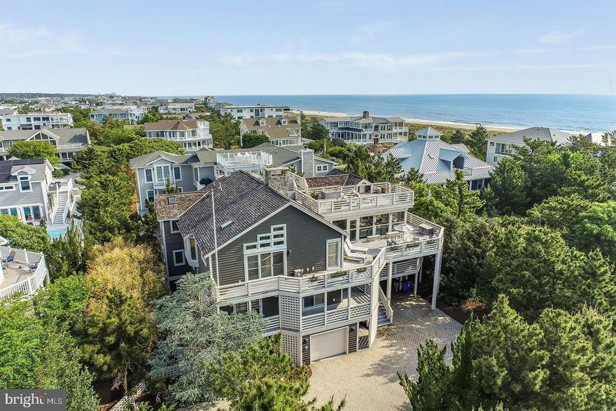 Welcome to 7 Hall Avenue in Indian Beach. This tastefully appointed custom home by Boardwalk Builders offers convenience to the community’s beautiful private beach. This location offers miles of coastline for peaceful walks, morning jogs or beach combing. 7 Hall Avenue is also conveniently located across from the Rehoboth Beach Sailing Association, and less than a quarter of a mile to the Rehoboth Bay Marina – ideal for boating and water sport enthusiasts. Situated in close proximity to downtown Dewey and Rehoboth Beach, this location leaves little to be desired. Offering +/- 5,200 square feet of heated living space, this custom-built residence features a very functional and open, 3-level floor plan complete with elevator access to each level. Upon entry, guests will be welcomed by beautiful travertine tiled floors, 2-story open hallway featuring a wood burning fireplace, 5 bedrooms each with private, en-suite baths, a laundry room and a spacious game room/office area featuring custom built-ins and a private half bath. A gorgeous open staircase will lead you to the third level featuring a gourmet kitchen with Wolfe and Subzero appliances, large breakfast bar and plenty of storage. A dining area neighbors the kitchen and is situated central to the living spaces making it ideal for entertaining and gatherings. This level is drenched with sunlight from the many floor to ceiling windows and skylights and features a beautiful stone, wood burning fireplace. This level also includes a cozy den, complete with a beverage fridge, ice maker, and wet bar as well as the master suite. The master bedroom is spacious and offers private access to the relaxing screened porch. The ground level of the home also offers travertine floors, and easy access to a full bath which is accessible from outdoors, perfect for beach breaks. This level is also home to spacious garages, ideal for vehicles and beach toys and a spa-style outdoor shower. The home’s numerous sun decks and screened porch offer superb exterior living. Take in ocean views and phenomenal sunsets from the rooftop perch which is ideal for morning yoga or an after-dinner night cap. This home is being sold mostly furnished and ready for this season's enjoyment.  7 Hall Avenue should not be overlooked!