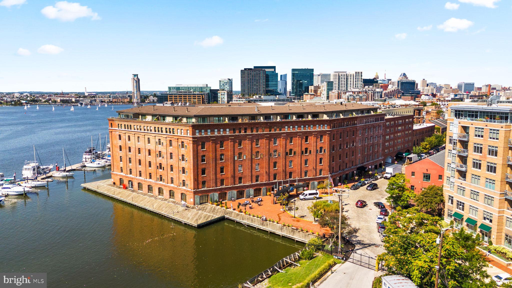Nestled at the end of picturesque cobblestone streets in historic Fells Point, this spacious condo is located in Henderson’s Wharf—the premier luxury waterfront building in the area. Offering an unparalleled blend of charm, history, and modern convenience, this one-level home is perfect for both entertaining and everyday living.
Inside, you’ll find an open-concept floor plan with abundant storage, a bright kitchen featuring stainless steel appliances, subway tile backsplash, open shelving, and a pass-through to the dining area for effortless hosting. The serene second-floor setting overlooks a private tree-lined courtyard, bathing the unit in natural light while providing a peaceful retreat.
Additional highlights include: In-unit laundry with stackable washer & dryer, Updated flooring throughout, Two separate heating/cooling zones with individual thermostats, Owner-owned indoor parking
Henderson’s Wharf offers an impressive array of amenities: a 24-hour gym, modern lobby and guest lounge, full-service front desk with package concierge, secure entry, bike storage, and continuous building updates that reflect its high standards.
Step outside your door to enjoy waterfront biking, running, and walking paths—or explore Fells Point’s renowned dining, shopping, and nightlife. With close proximity to major hospitals and new retail centers, this location balances convenience with lifestyle.
Mortgage savings may be available for buyers of this listing.