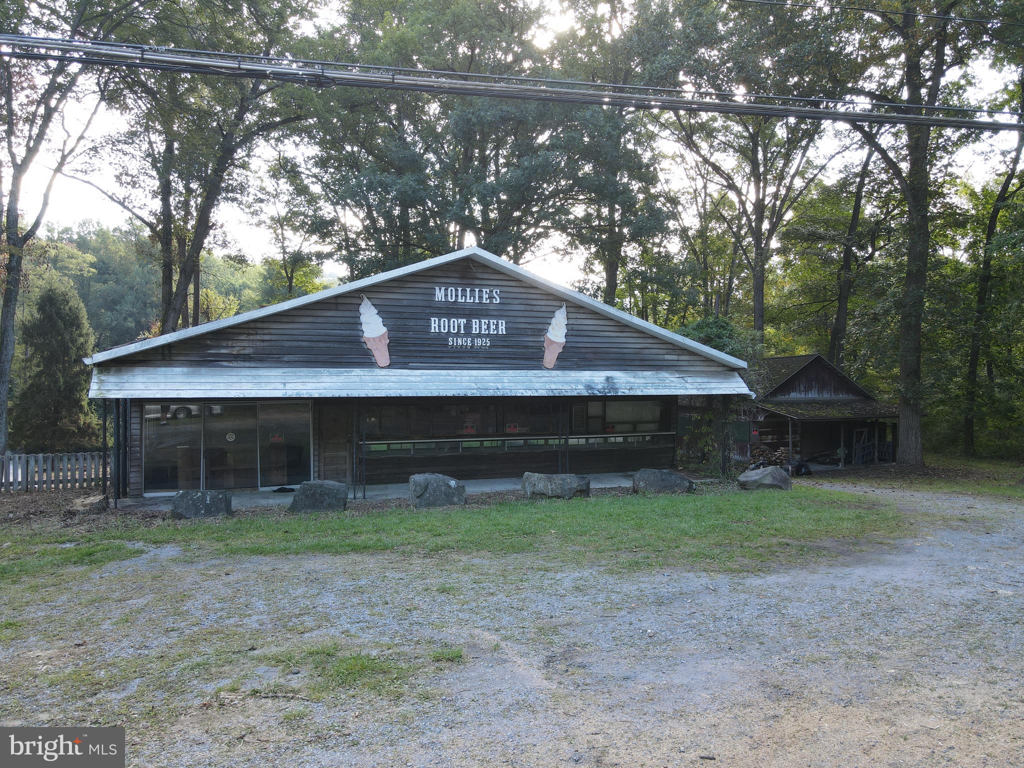 This property will be offered at Public Auction on Monday, October 13, 2025 @ 6pm. The listing price is the opening bid only and in no way reflects the final sale price. 10% down due at auction, 2% transfer tax to be paid by the purchaser, real estate taxes prorated. This 23.43-acre property, zoned General Commercial, is full of opportunity and ready for your ideas! The main building, once an ice cream shop and restaurant, includes a dining area, kitchen, office/living space, full bathroom, ice cream room, and prep/storage area. Also on the property is a 1920’s dance hall with a 43’ x 24’ open area and stage, as well as a two-story home with 4 bedrooms, kitchen, living room, and full bathroom. Other unique features include a brick spring house with three artesian springs—used for coin-operated spring water sales—a central restroom facility for guests, mature timber and the Shearers Creek running through the property, and individual drain fields for each building. With multiple buildings, historic charm, and unique natural resources, this property offers endless possibilities—whether you’re starting something new, expanding your business, or creating a one-of-a-kind destination!