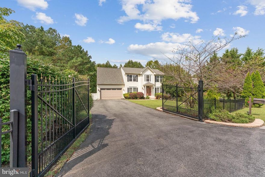 Retreat into this immaculate 3 bedroom, 3 1/2 bath, 2-car garage home sanctuary on 1.19 acres.  This home has been lovingly and meticulously maintained and updated.  Through a gated expanded driveway, the yard features beautiful hardscaping and landscaping.  A welcoming two-story, light-filled foyer greets all who enter.  The main level has gleaming hardwood throughout.   Spacious Formal Dining and Living Room flank the entry.  Gather in the rear of the home in the well-appointed Eat-In Kitchen and expansive Family Room with pellet stove.  The Kitchen features lots of granite countertop space and an island for meal prep and plenty of storage within the custom cabinetry.  Dining and entertaining can be taken outside onto the large, covered Trex deck that expands across half of the home.  Upstairs, the large Primary Bedroom has a dreamy Walk-In Closet with a washer and dryer for extra convenience.  The Primary Bath has a dual vanity, soaking tub, large glass-enclosed shower, and separate wash closet.  Two other well-sized Bedrooms and Full hall Bath finish out the upper level.  The amount of detail in this versatile, fully finished basement will wow you.   The large space has luxury plank vinyl flooring, a sink, custom cabinetry, granite, small refrigerator, microwave, pellet stove, custom built-ins, and walk-out level onto its own deck.  In addition, there is a newly remodeled full bath, an office with a closet, and a hobby or playroom.  The backyard is a private oasis featuring mature fruit trees, raised gardens, hardscape, play structure, a shed, all overlooking a forest preserve.  This home is serenely tucked away from the hustle and bustle, yet still close to everything.  Freshly painted throughout and new carpet.  Easy commute to DC, JBA, Pentagon, Alexandria, Arlington, Indian Head, and National Harbor.  Close to shopping, dining, parks and entertainment.