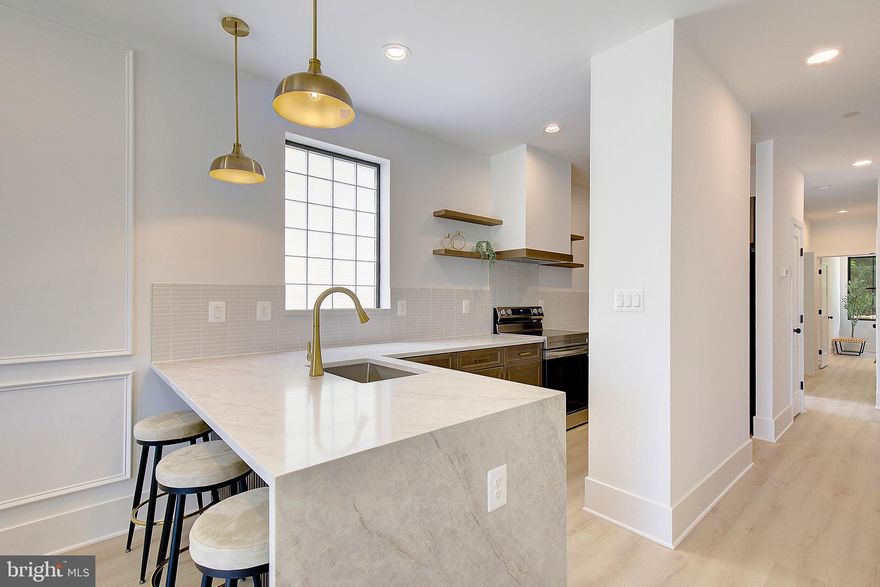 Experience the serenity of this brand-new 2-bedroom, 2-bathroom luxury bayside sanctuary located just one block from the Chesapeake Bay in the heart of North Beach. Thoughtfully designed as an organic modern retreat, this residence offers sophisticated finishes as well as water views from your living room and front garden patio. Step inside to discover exquisite features and upgrades throughout, including: MSI "Taj Mahal" waterfall countertop that anchors the sleek kitchen, luxurious gold hardware, custom picture frame wall moulding, and a striking rough-cut Alamo Sandstone fireplace wall that adds warmth to your living space. Each bathroom is finished in a zen-inspired style with custom tile work, designed to reflect a modern spa-like retreat. The primary suite includes a spacious walk-in closet and a beautifully appointed en-suite bathroom. Step outside your door and you're just a block from the beach, boardwalk, restaurants, shopping, cafes, and weekend events. Enjoy the charm of North Beach with the convenience of a quick commute—30 minutes to Joint Base Andrews, 40–45 minutes to Washington, DC, Northern Virginia, and Annapolis. Tour today and discover the best of North Beach living. Broker/owner